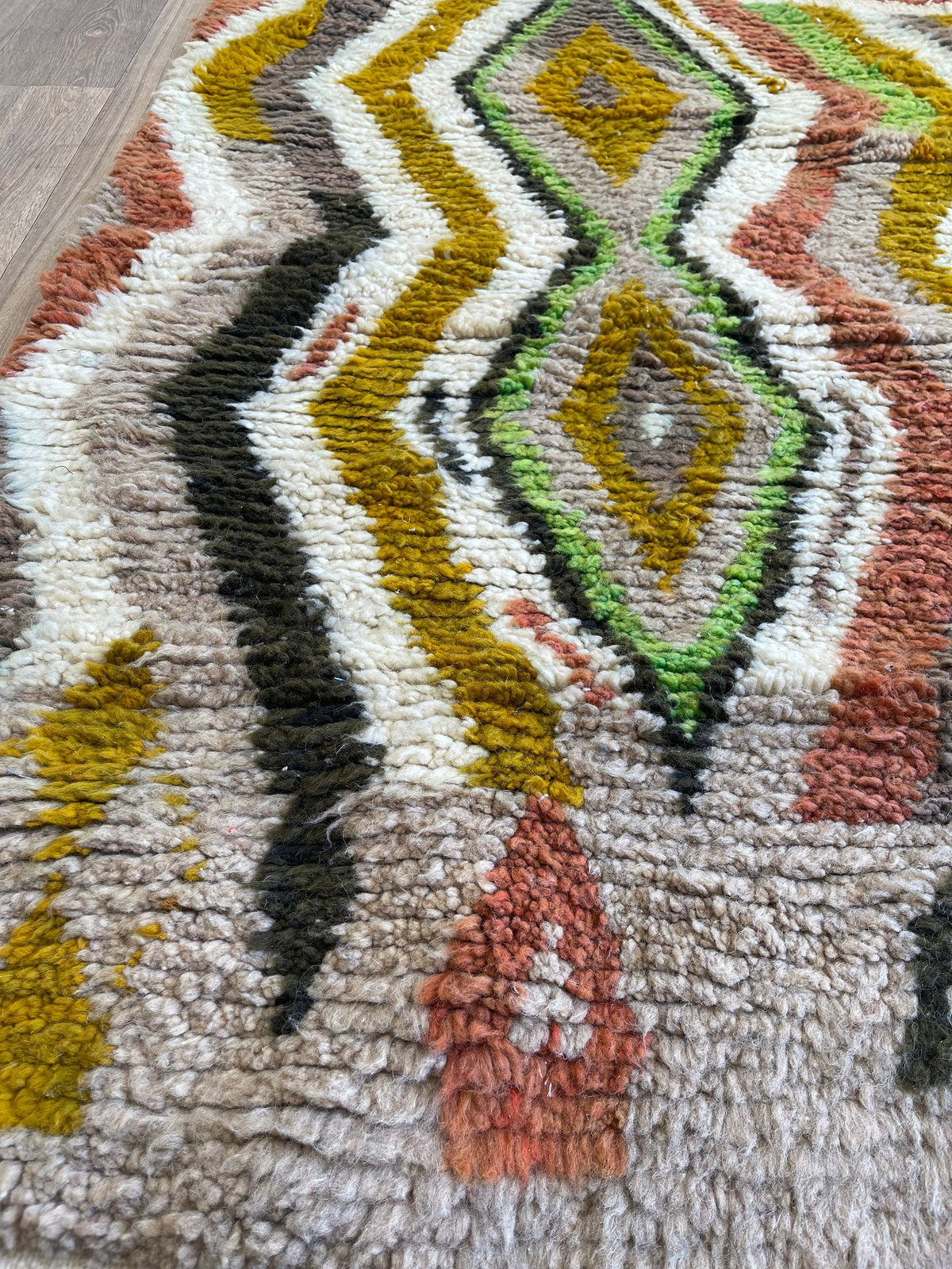 Gros plan sur la laine du tapis berbère Nabroud, nœuds serrés et tracé du motif de près