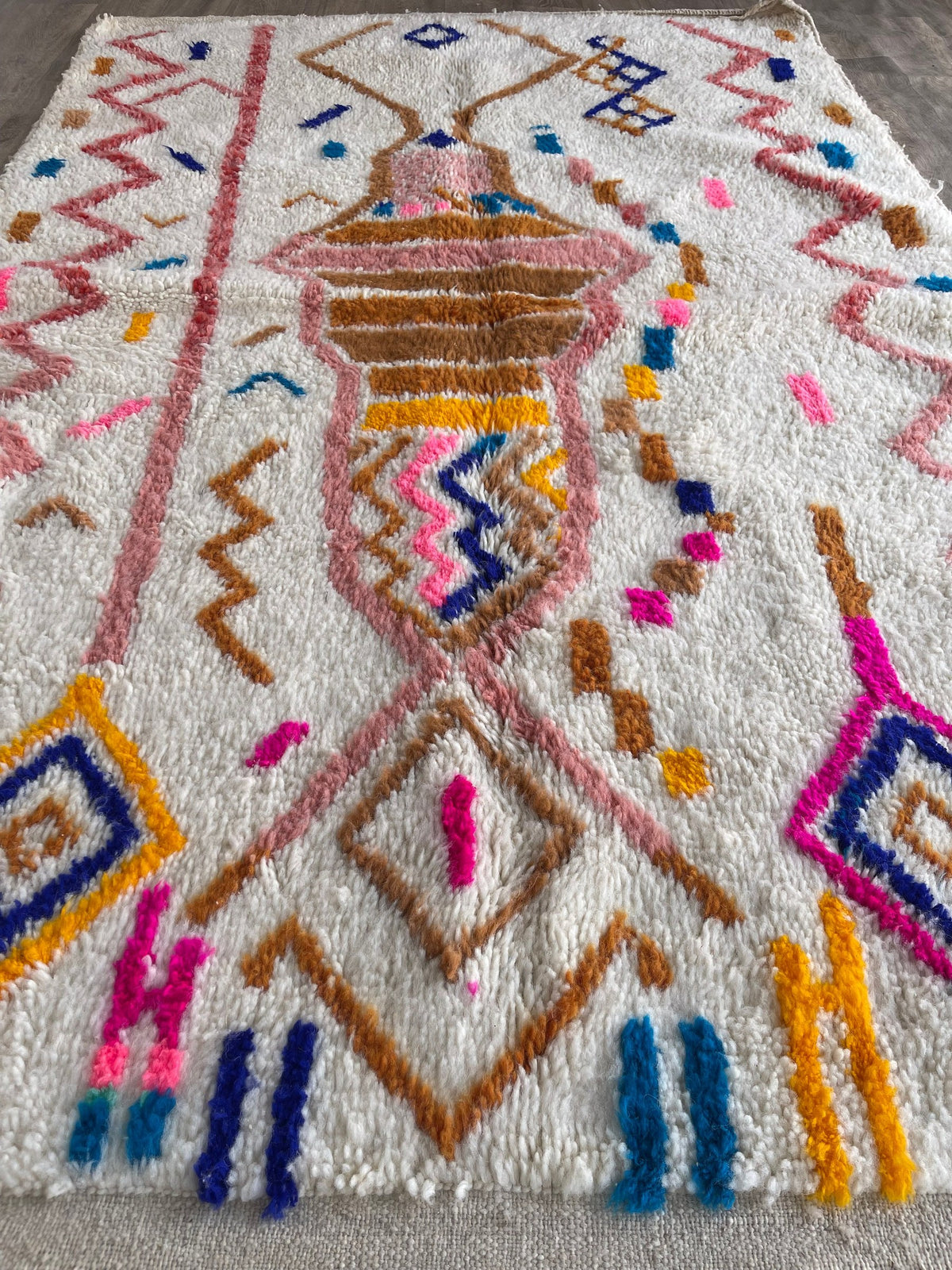 Gros plan sur un détail du tapis berbère Demnate, poil long et motif multicolore vus de près