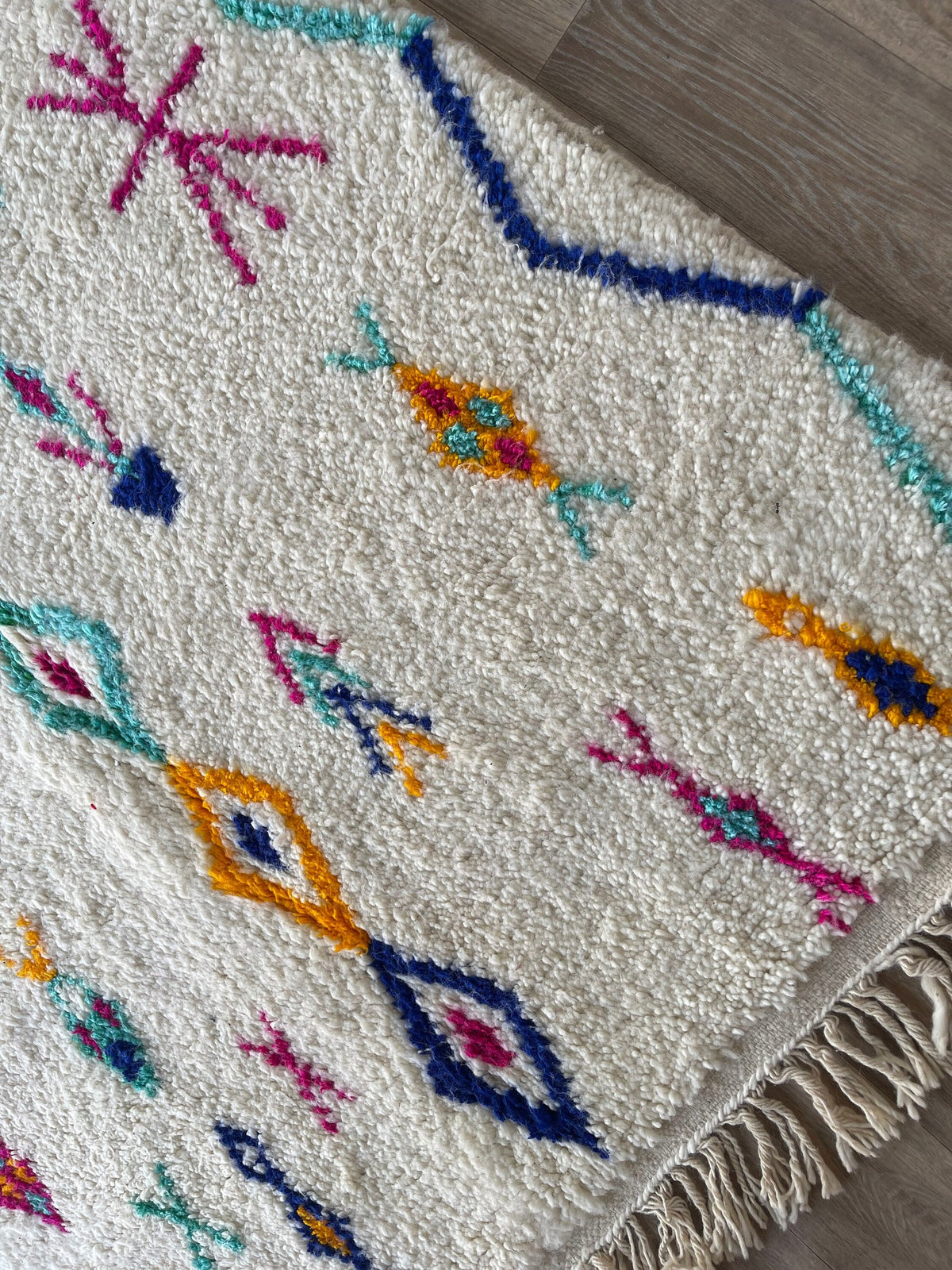 Gros plan sur le coin relevé du tapis berbère Sekkura, épaisseur du poil moyen et dos tissé à la main