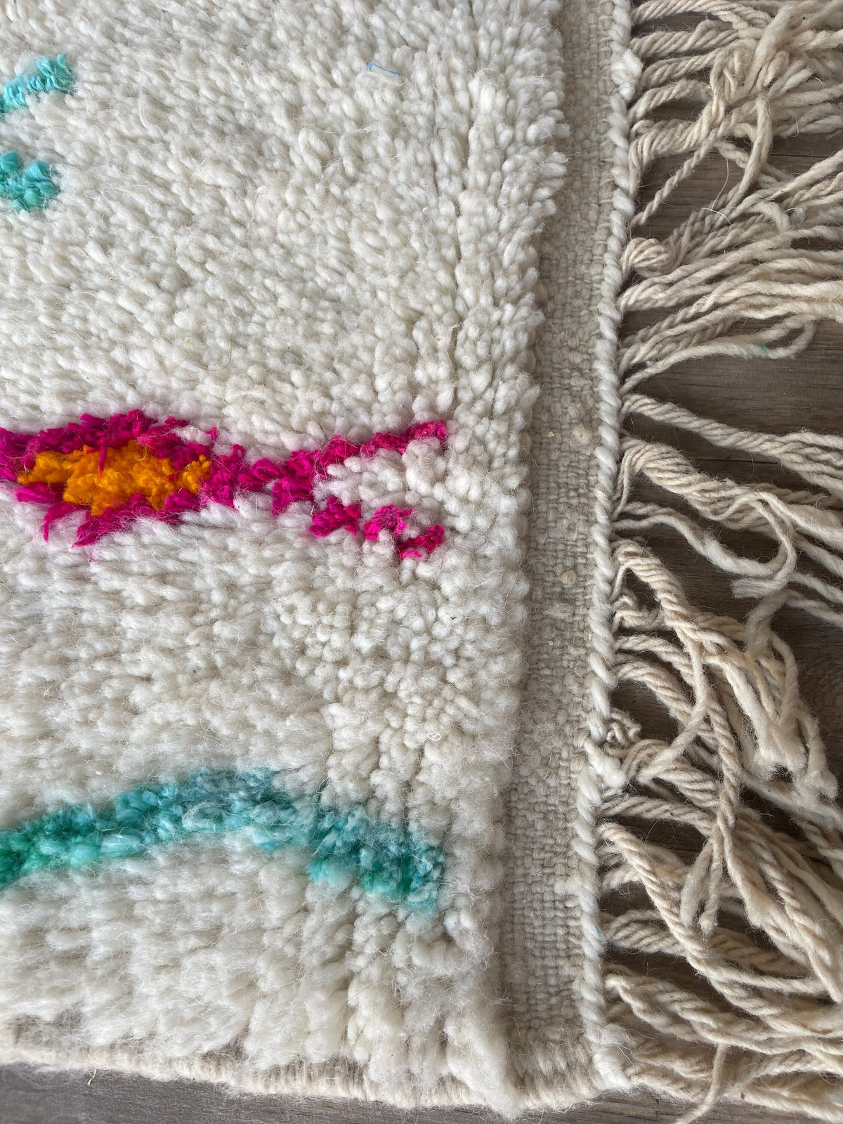 Gros plan sur les franges du tapis berbère Sekkura, écrues, nouées à la main