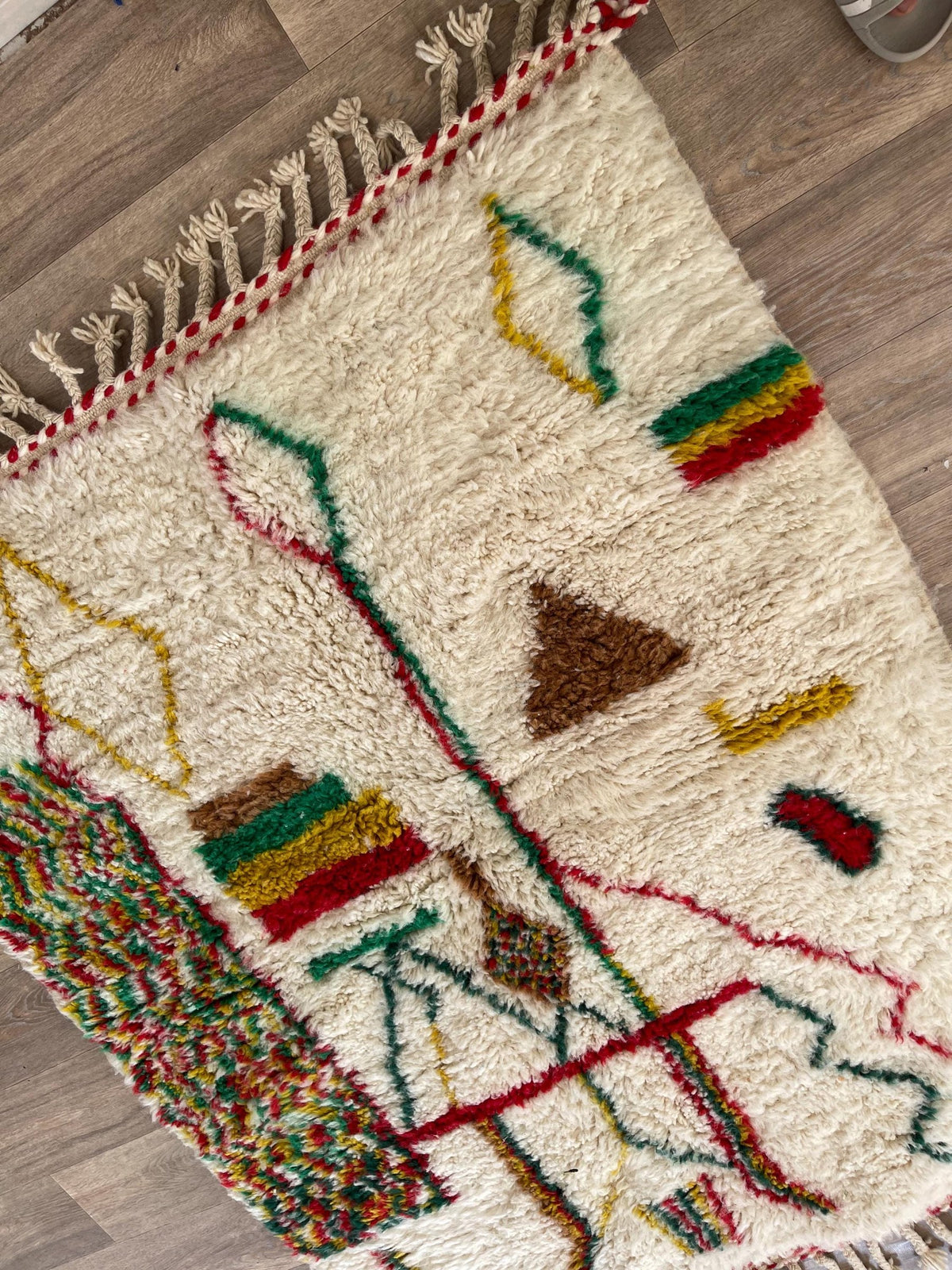 Gros plan sur un détail du tapis berbère Tabant, poil long et motif multicolore vus de près