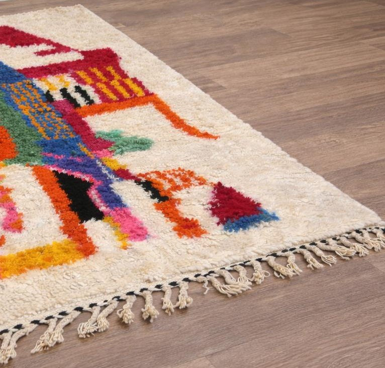 Tapis berbère style Azilal multicolore Tamawayt posé au sol vu de côté, noué main au Maroc