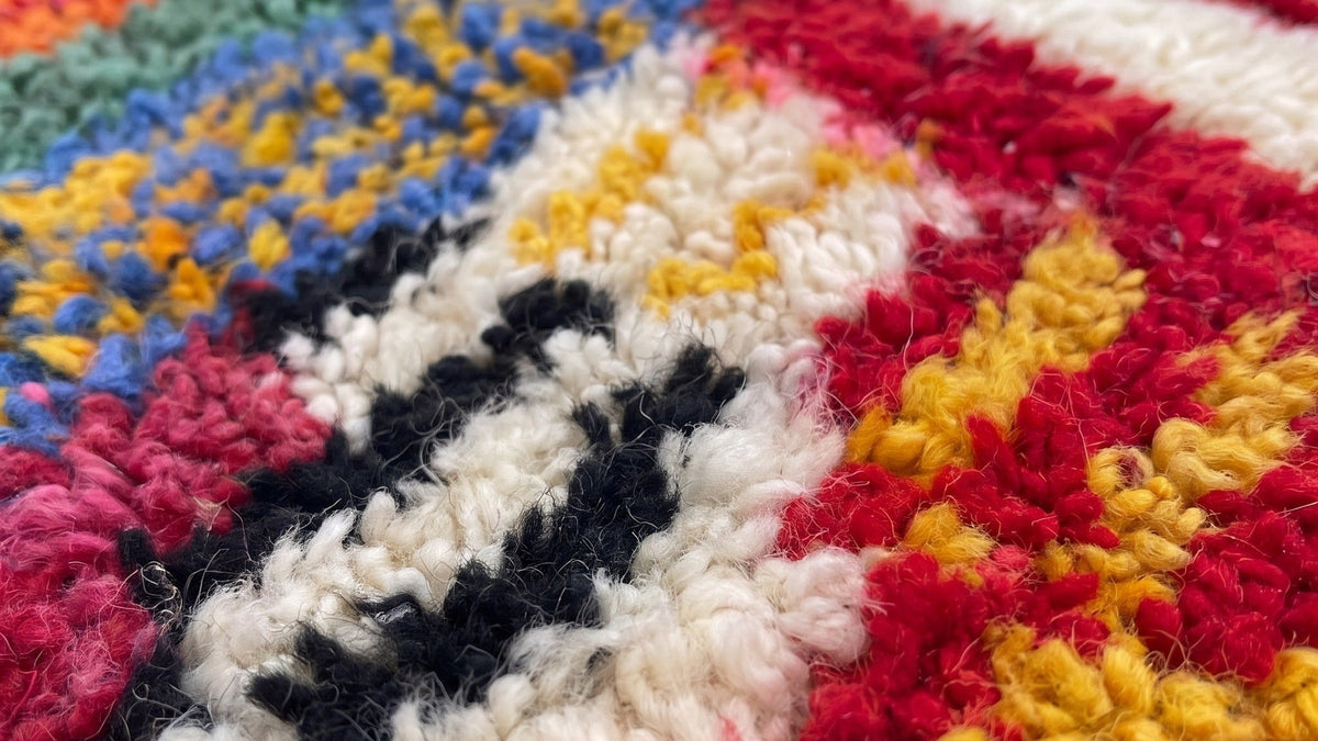 Gros plan sur la laine du tapis berbère Tamawayt, poil multicolore noué à la main