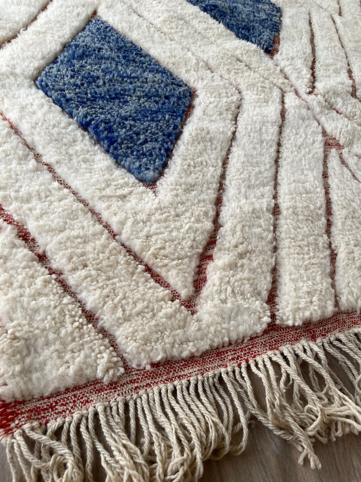 Gros plan sur les franges du tapis berbère Aman, écrues libres, nouées à la main