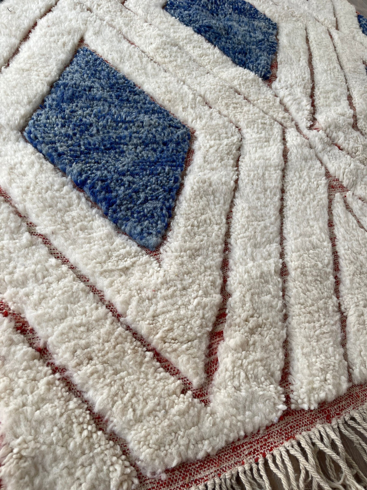 Gros plan sur la laine du tapis berbère Aman, nœuds serrés et tracé du motif de près