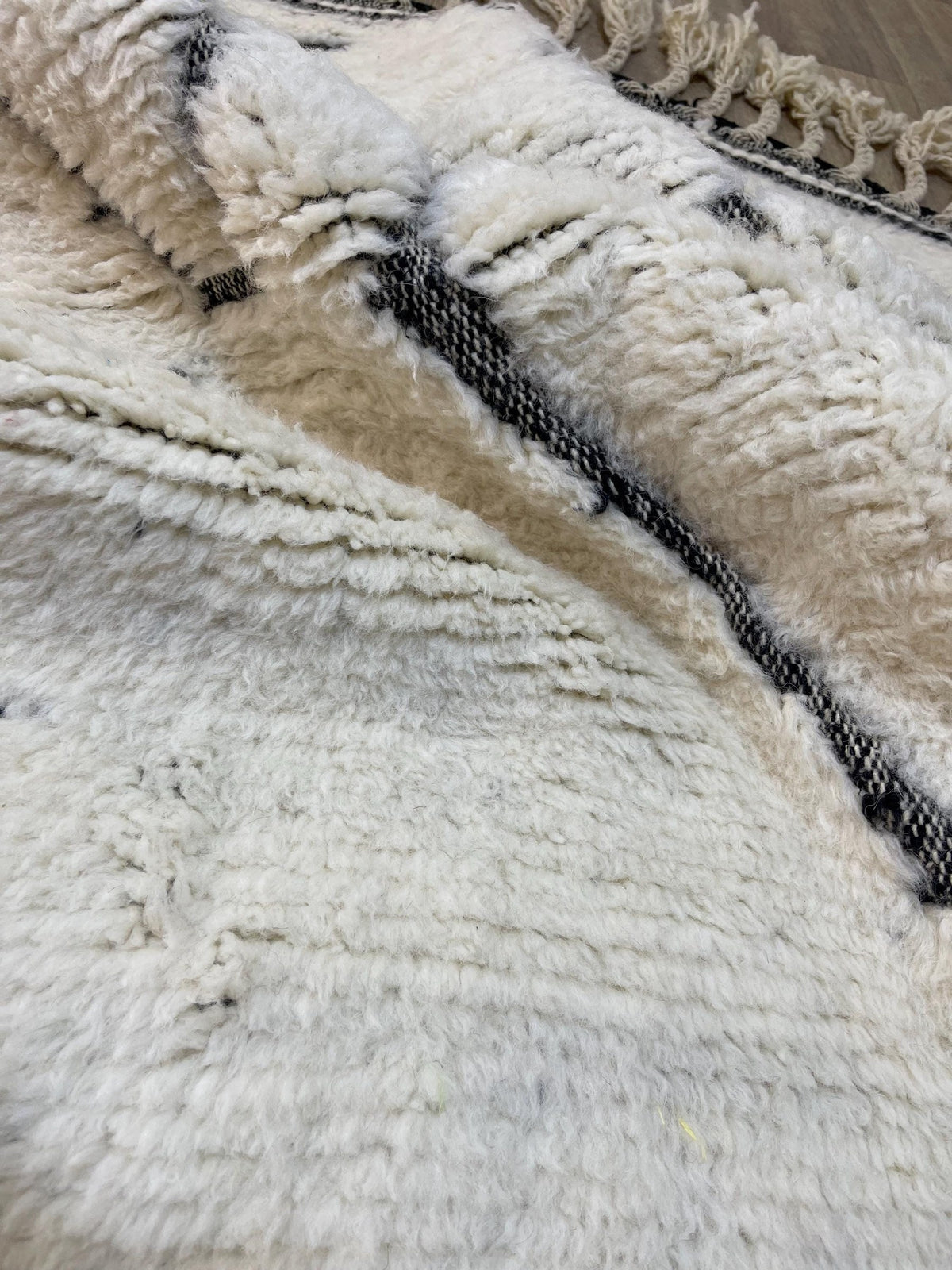 Gros plan sur la laine du tapis berbère Elzira, texture de la laine naturelle et nuances du poil