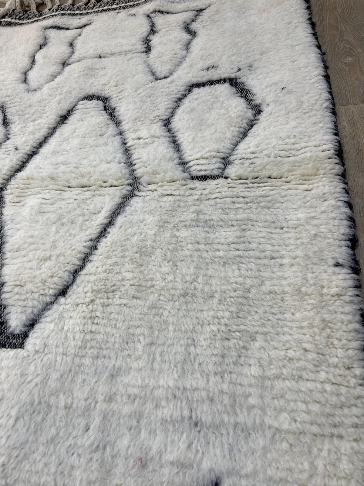 Gros plan sur un détail du tapis berbère Elzira, tracé irrégulier du motif fait main