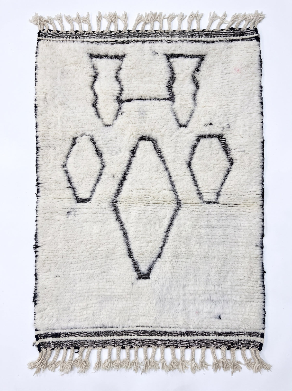 Tapis berbère style Beni Ouarain blanc et noir Elzira vu à plat, style Beni Ouarain à poil long bouclé, franges écrues tressées