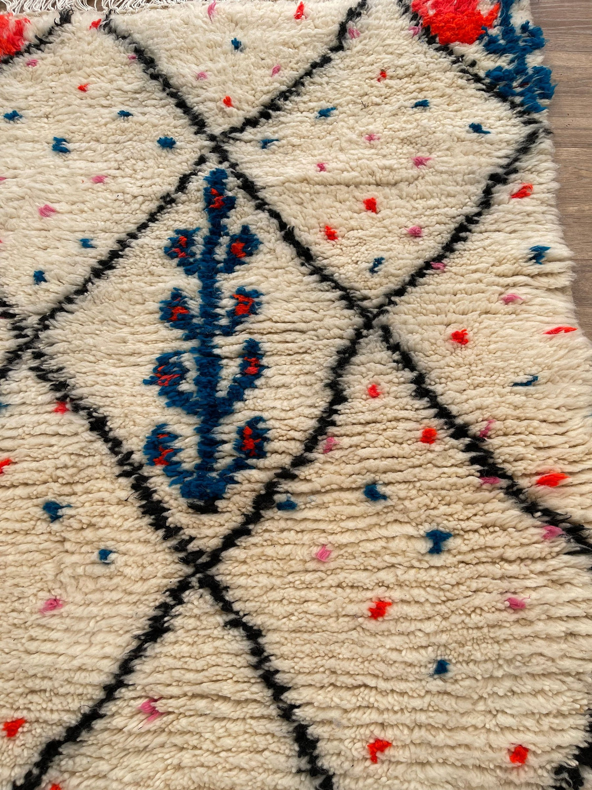 Gros plan sur un détail du tapis berbère Idmim, tracé irrégulier du motif fait main