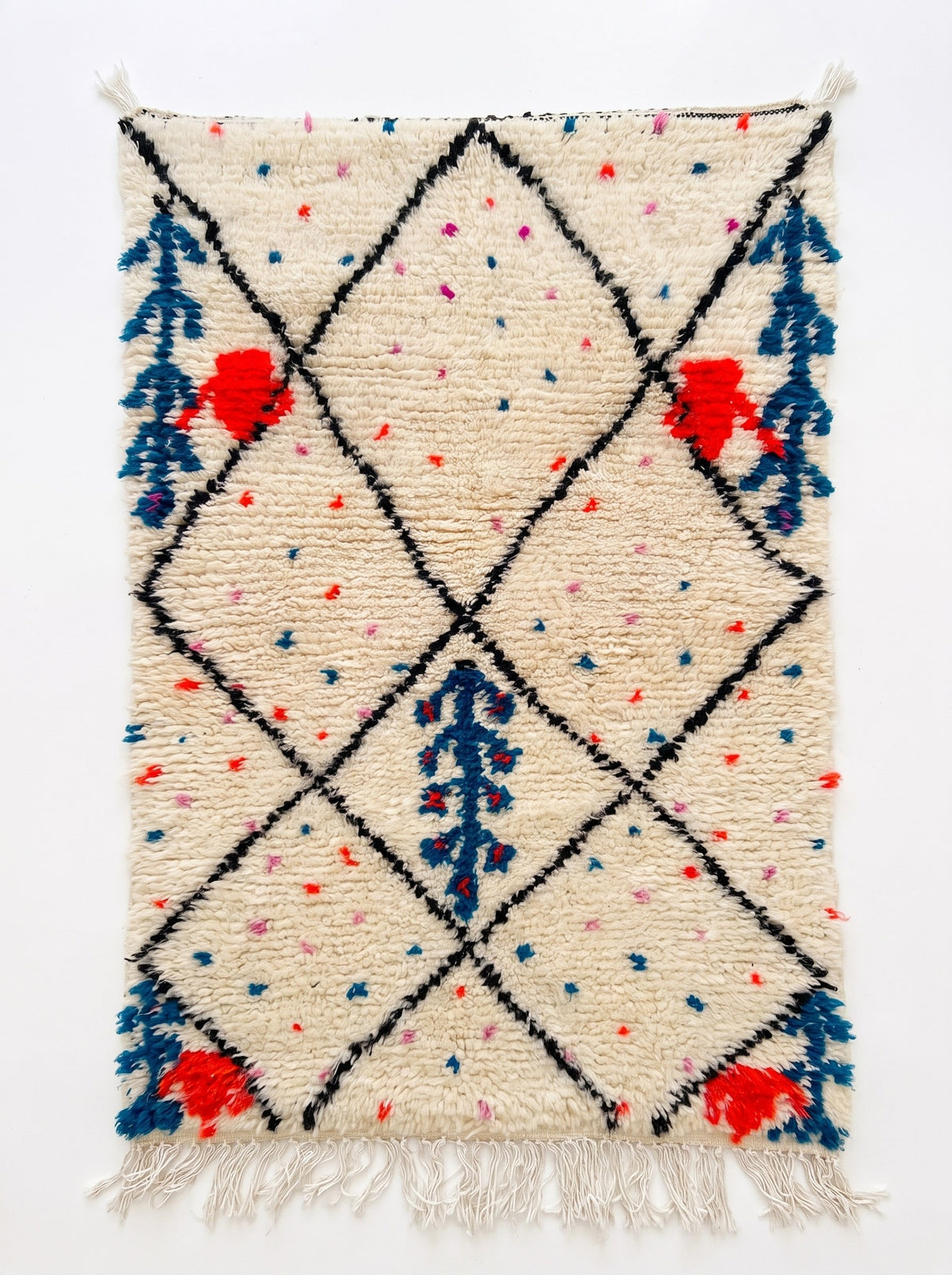 Tapis berbère style Beni Ouarain blanc et noir Idmim vu à plat, fond ivoire semé de points roses, franges blanches