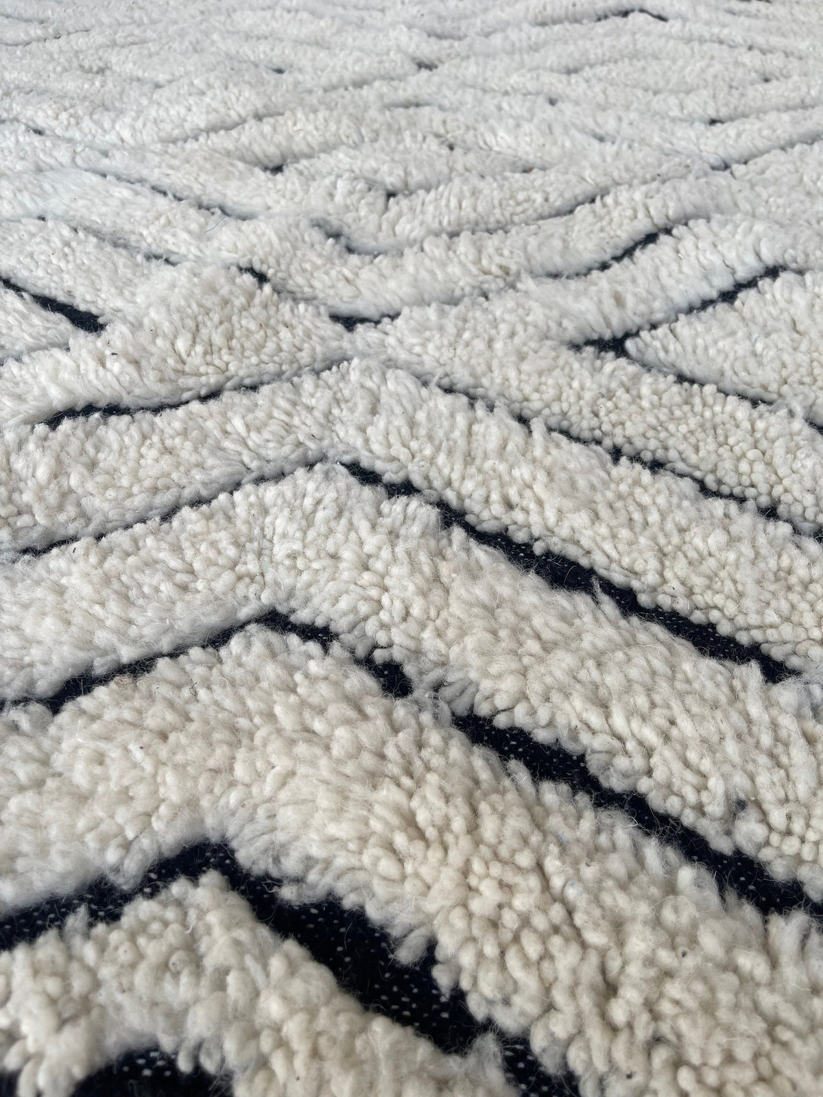Gros plan sur la laine du tapis berbère Ousmil, texture de la laine naturelle et nuances du poil