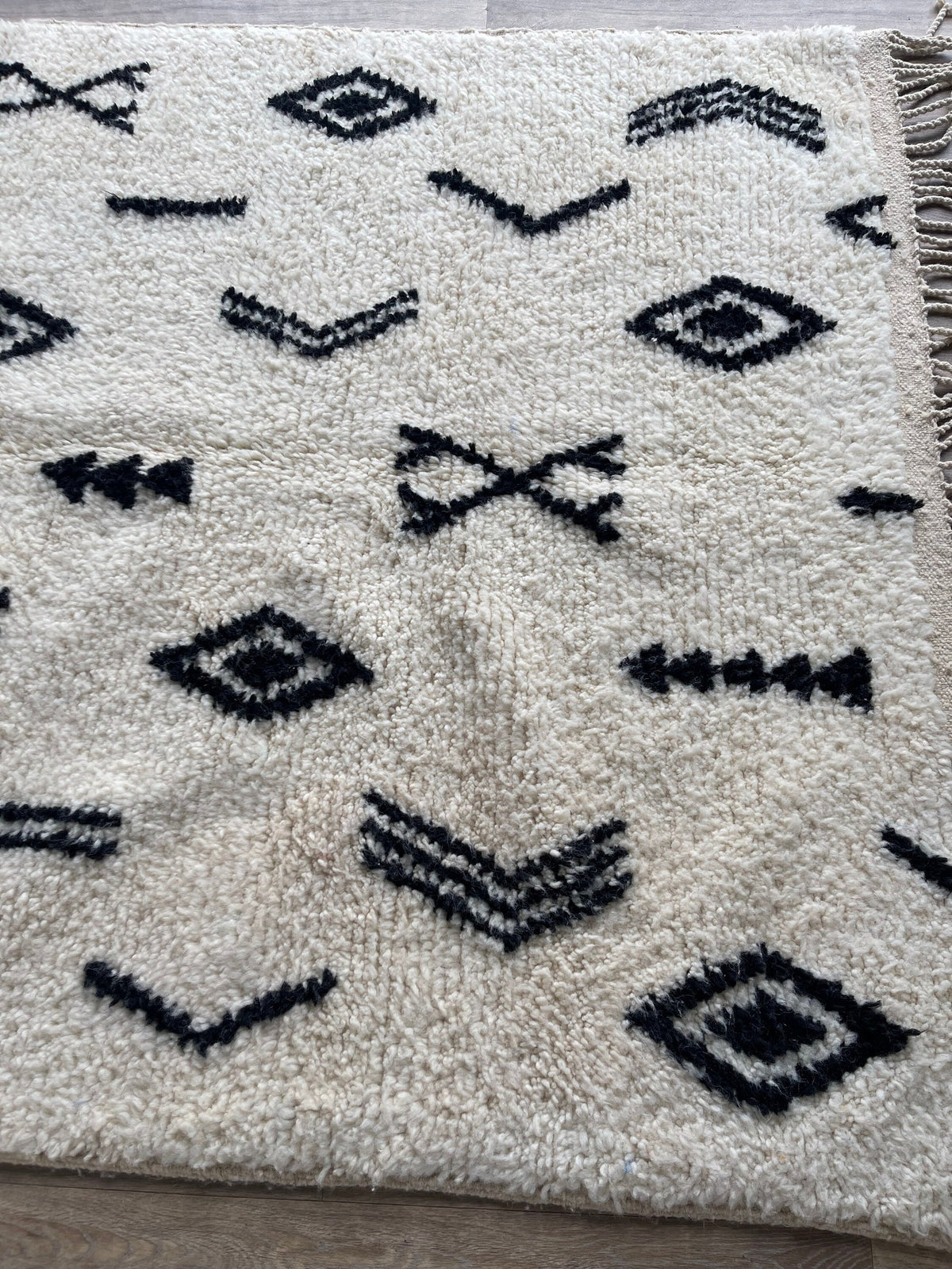 Gros plan sur un détail du tapis berbère Tasusmi, tracé irrégulier du motif fait main