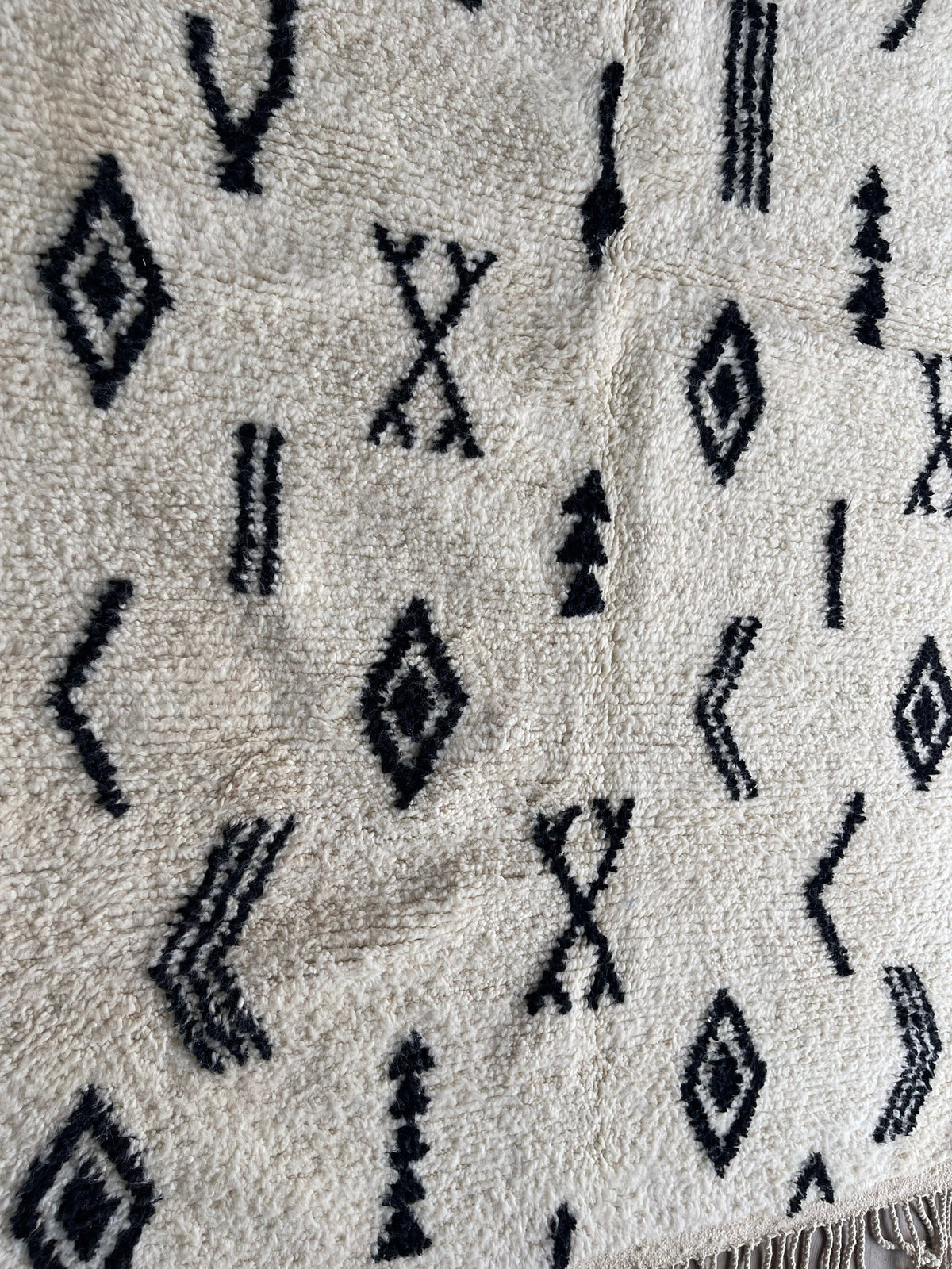 Gros plan sur un détail du tapis berbère Tasusmi, nuances de la laine et du motif de près