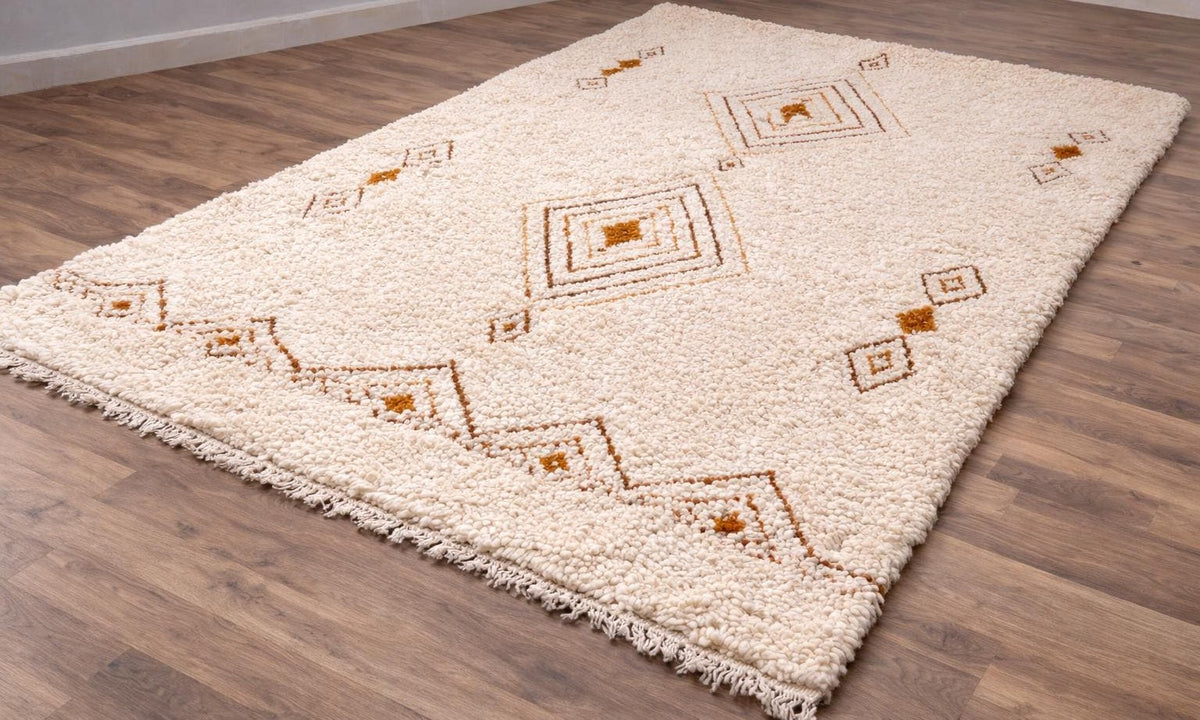 Tapis berbère style Beni Ouarain blanc et ocre Itran posé au sol vu de côté, noué main au Maroc