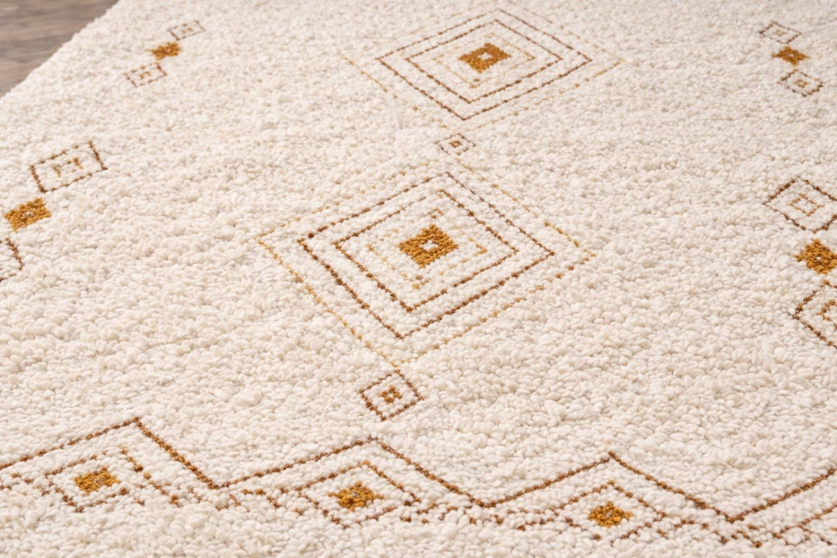 Gros plan sur la laine du tapis berbère Itran, laine de mouton au poil moyen, blanche et ocre