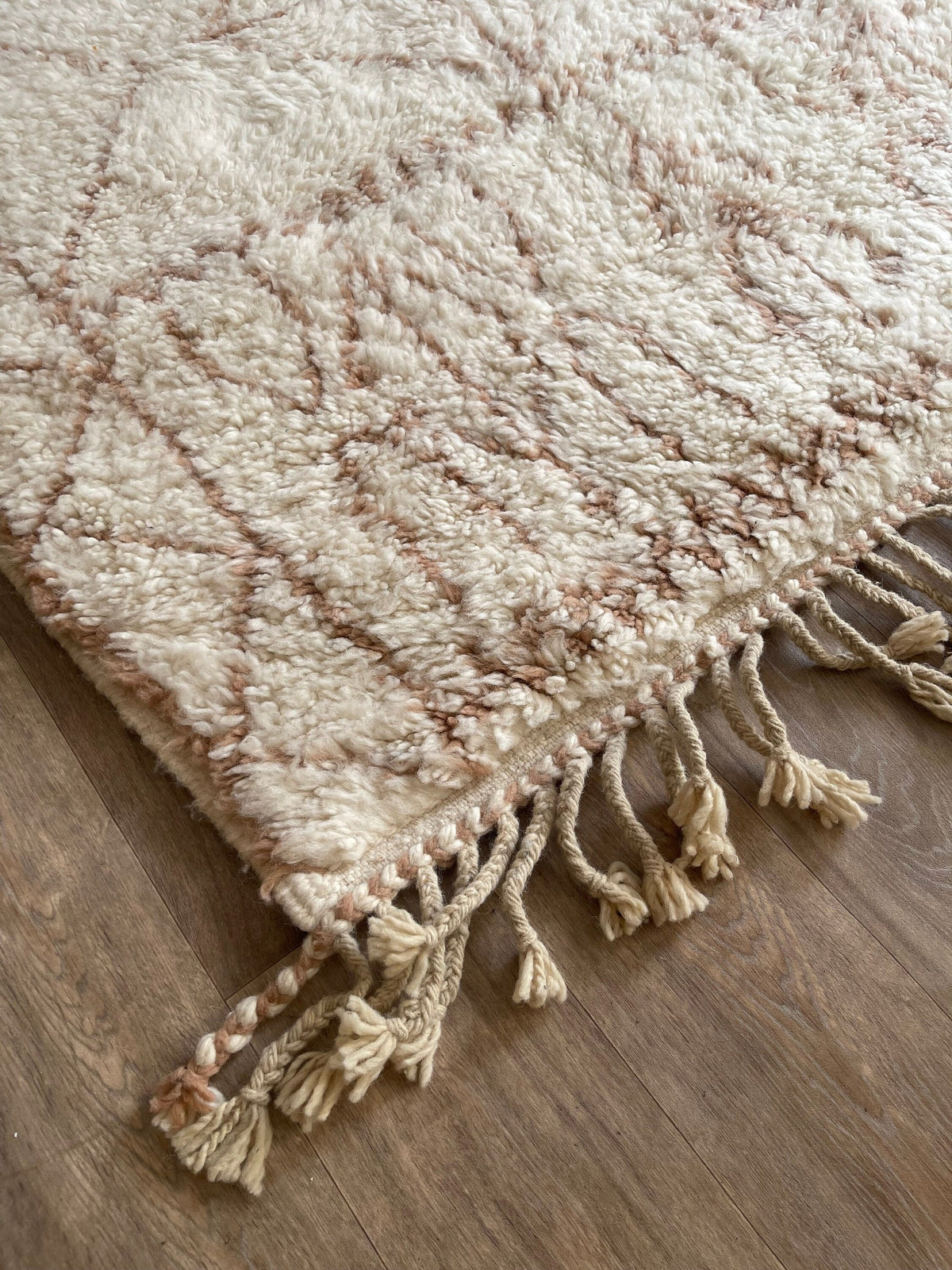 Gros plan sur le coin relevé du tapis berbère Timoulay, épaisseur du poil long et dos tissé à la main