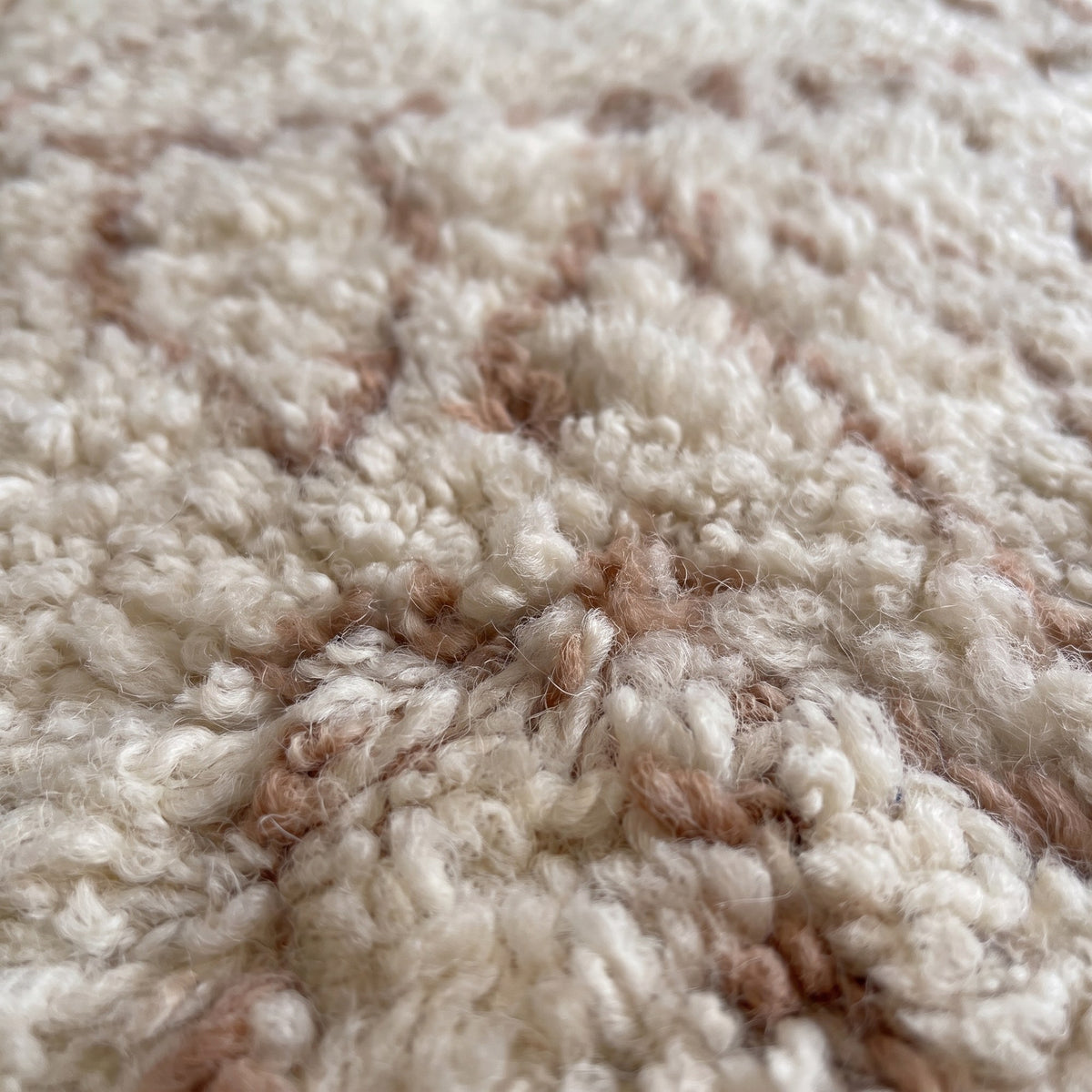 Gros plan sur un motif du tapis berbère Timoulay, écru à poil long, fines lignes brun rosé