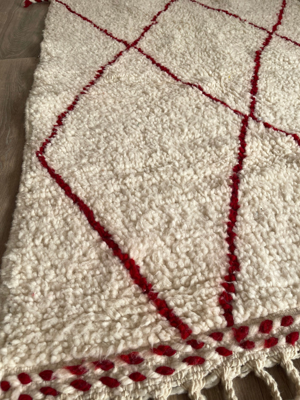 Gros plan sur les franges du tapis berbère Tanemmirt, bout du tapis, franges et bordure tissée
