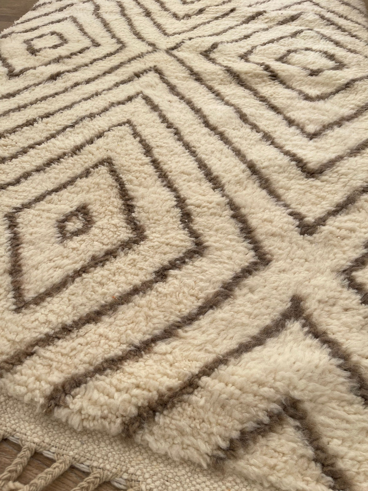Gros plan sur un détail du tapis berbère Almis, tracé irrégulier du motif fait main
