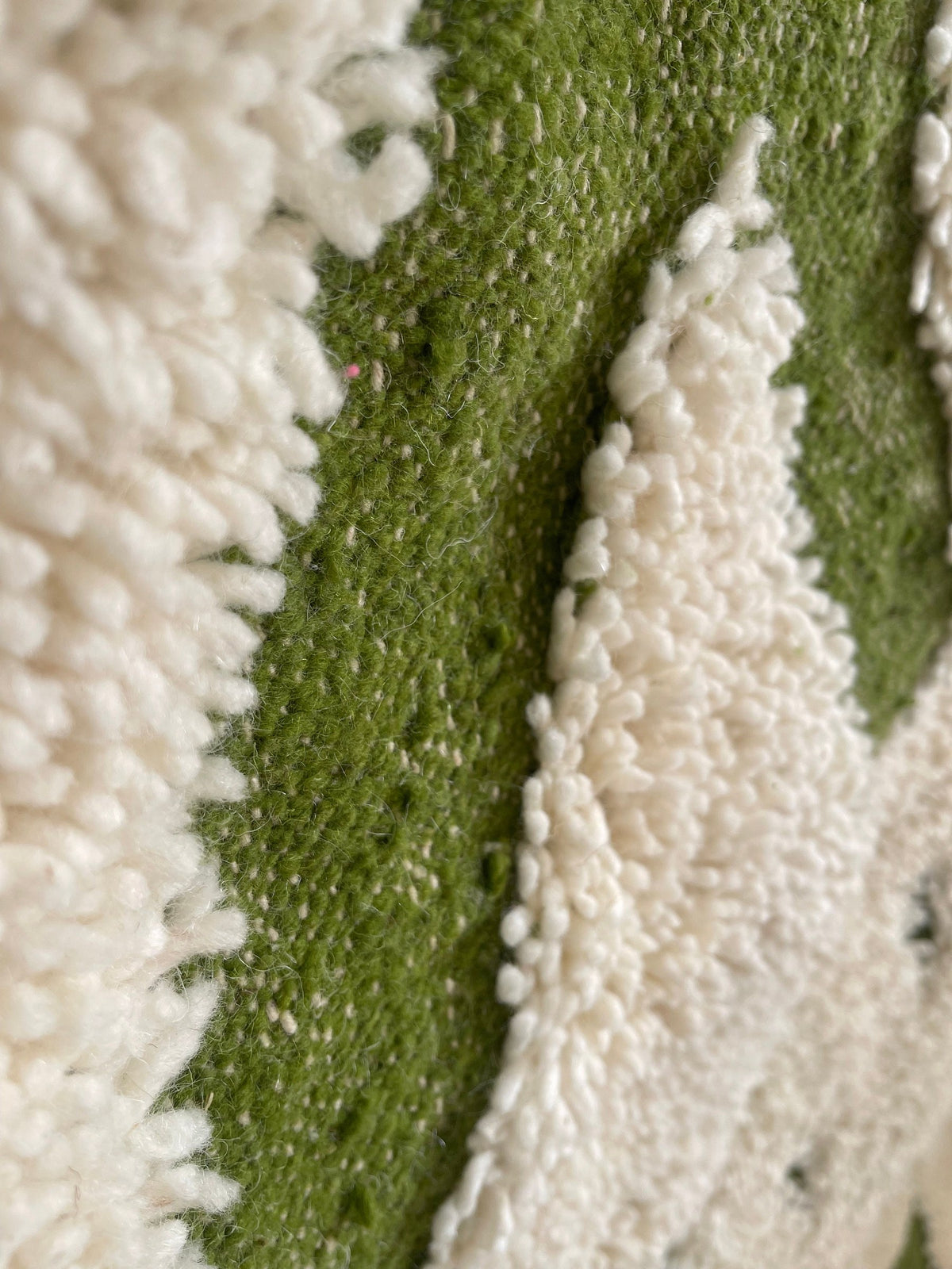Gros plan sur la laine du tapis berbère Tahanaout, nœuds serrés et tracé du motif de près