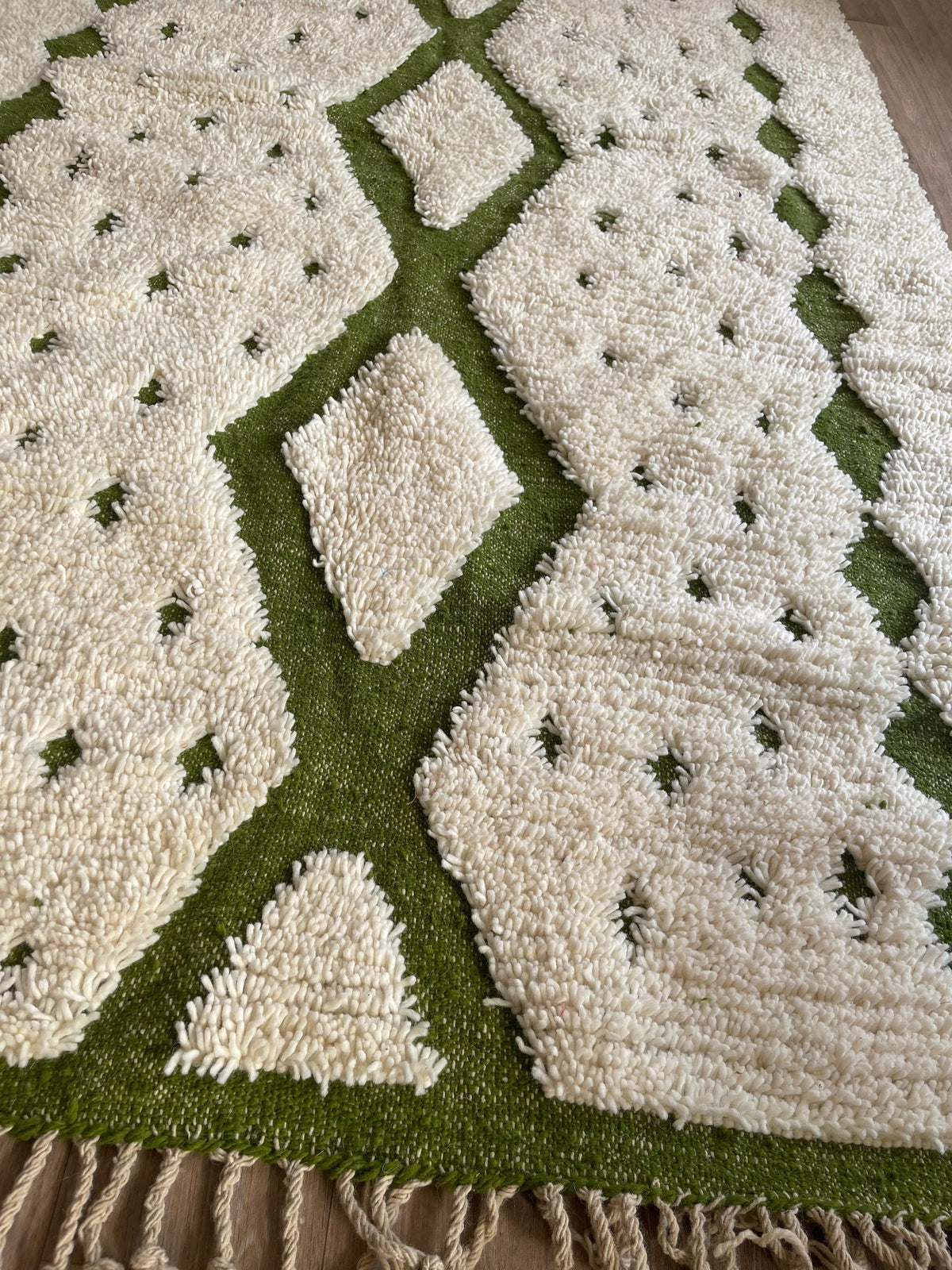 Gros plan sur un détail du tapis berbère Tahanaout, poil long et motif blanc et vert vus de près, vue 4