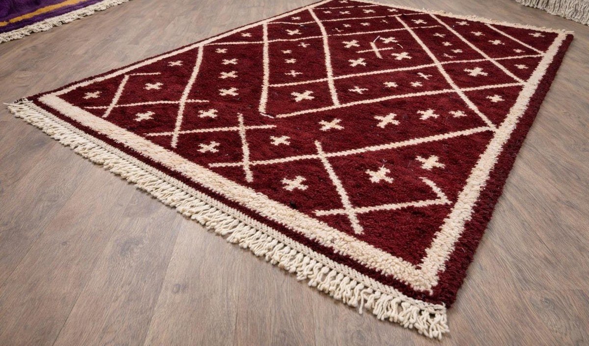 Tapis berbère style Beni Ouarain bordeaux Ammas posé au sol vu de côté, noué main au Maroc