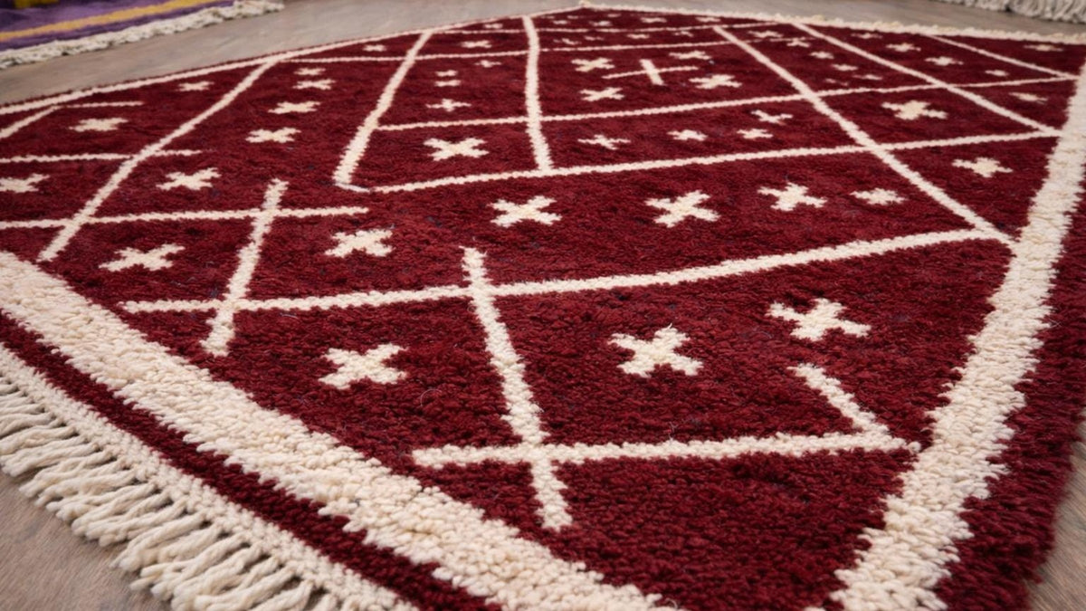 Gros plan sur la laine du tapis berbère Ammas, poil bordeaux noué à la main