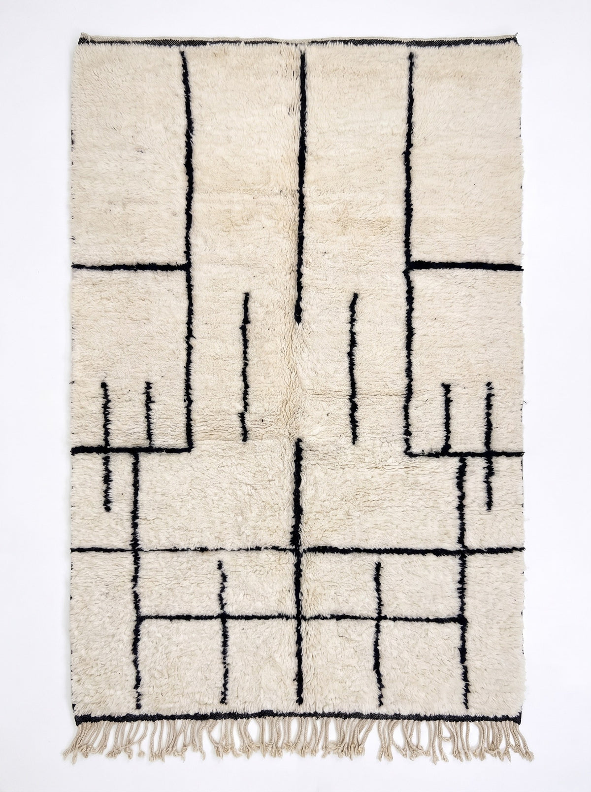 Tapis berbère style Beni Ouarain noir et blanc Ilzoun vu à plat, fond ivoire à poil long, en haut quatre longues lignes