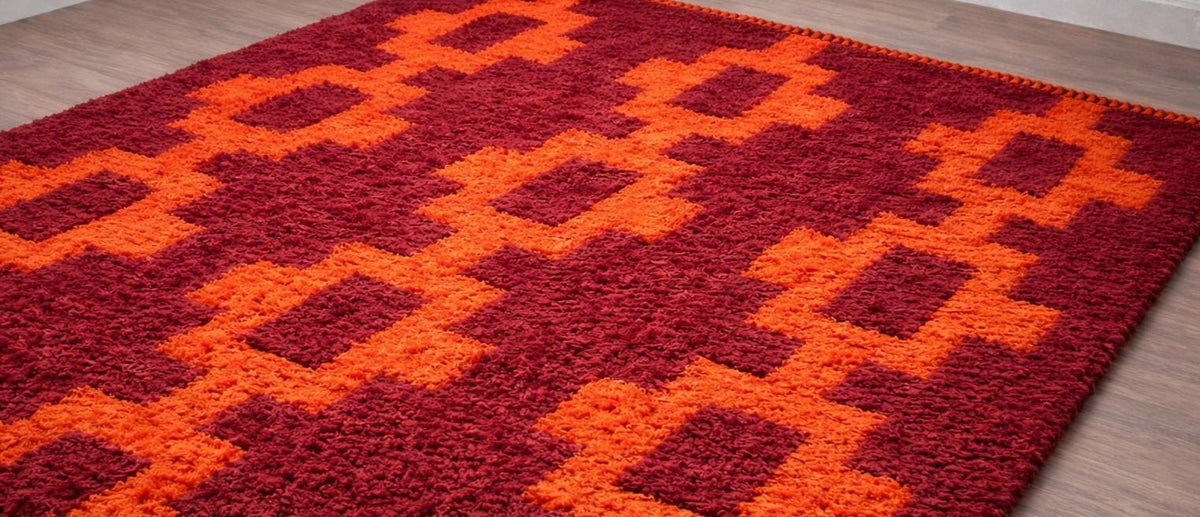 Tapis berbère style Boujad bordeaux et orange Izem posé au sol vu de côté, noué main au Maroc