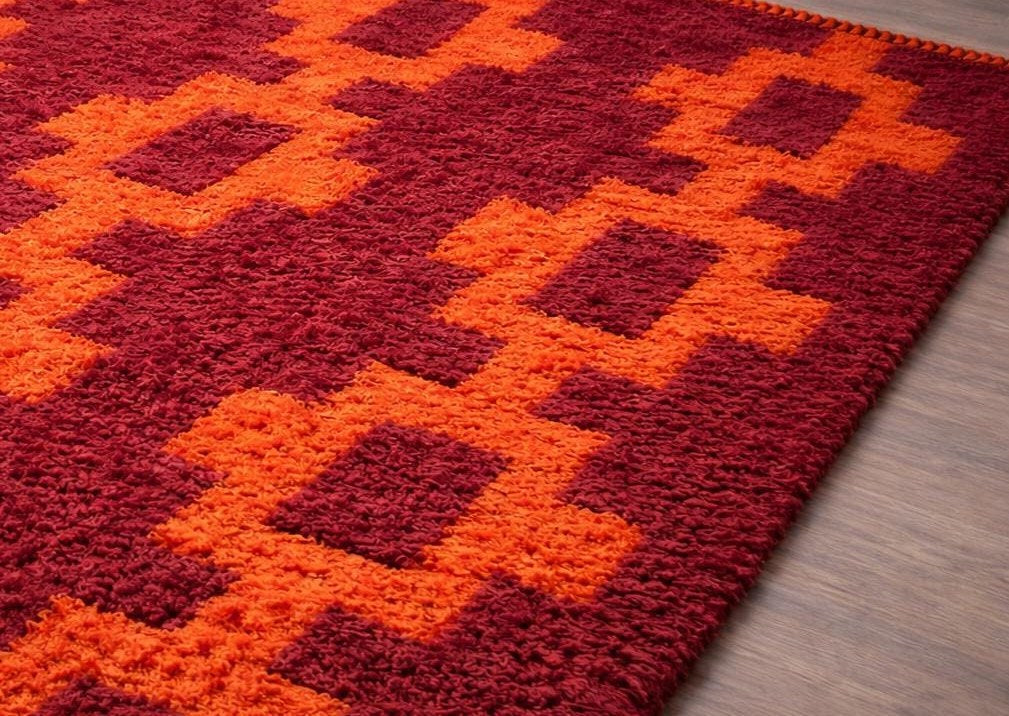 Tapis berbère style Boujad bordeaux et orange Izem posé au sol vu en biais, noué main au Maroc