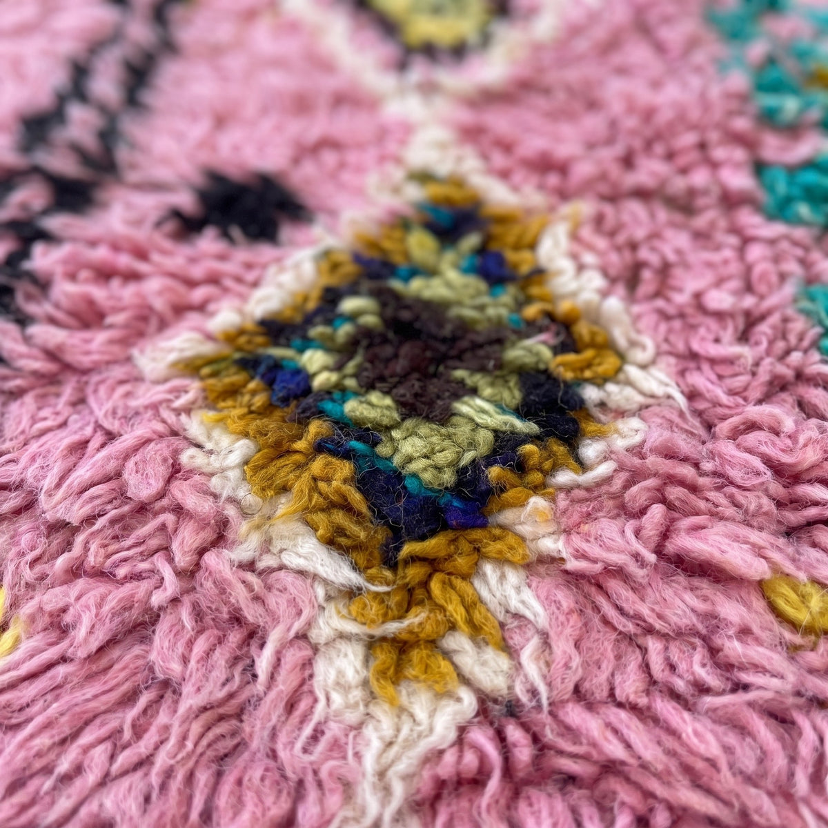 Gros plan sur un motif du tapis berbère Amezrou, boujad fond rose à poil long