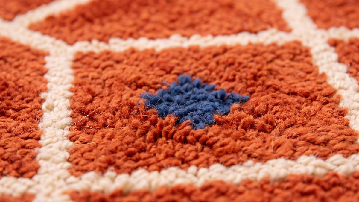 Gros plan sur la laine du tapis berbère Tiznit, poil terracotta noué à la main