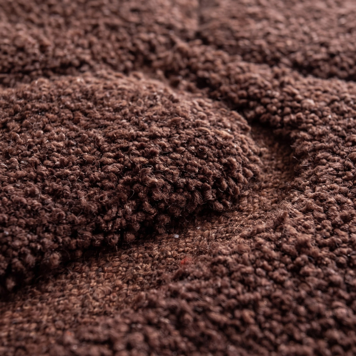 Gros plan sur un motif du tapis berbère Boulemane, brun chocolat uni, laine bouclée