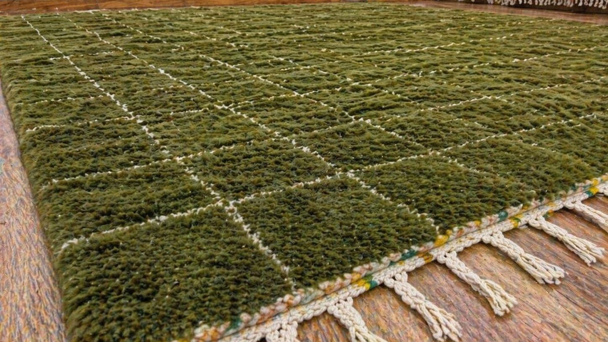 Gros plan sur la laine du tapis berbère Arbaoua, poil vert olive noué à la main