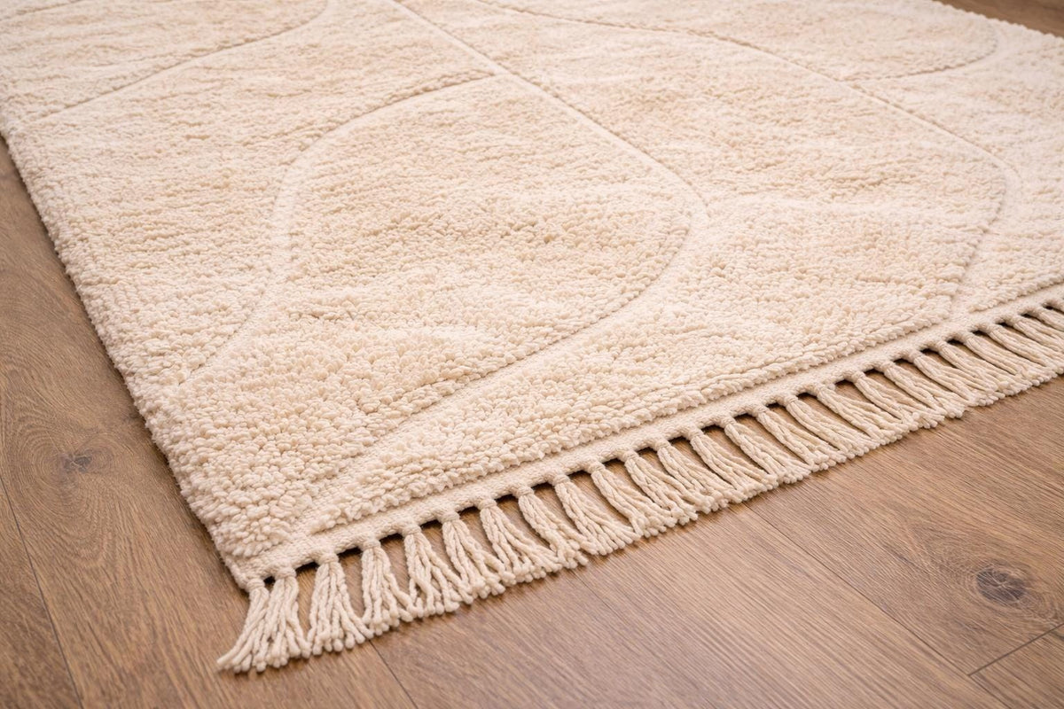 Gros plan sur les franges du tapis berbère Ifrane, crème tressées en bas seulement, nouées à la main