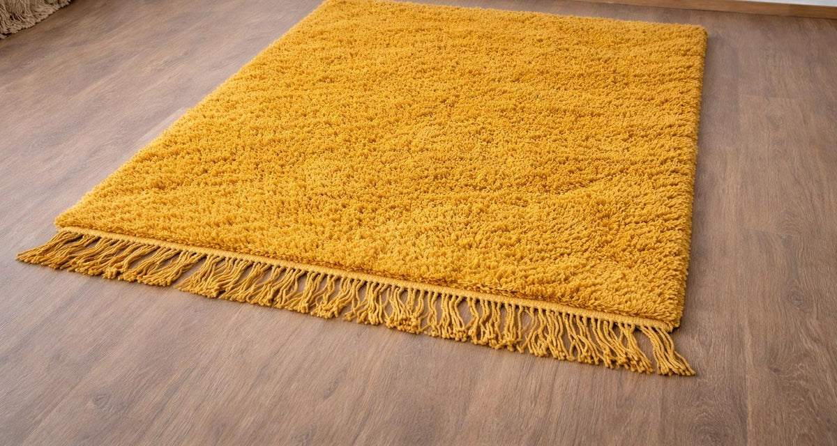 Tapis berbère uni moutarde Atay posé au sol vu de côté, noué main au Maroc
