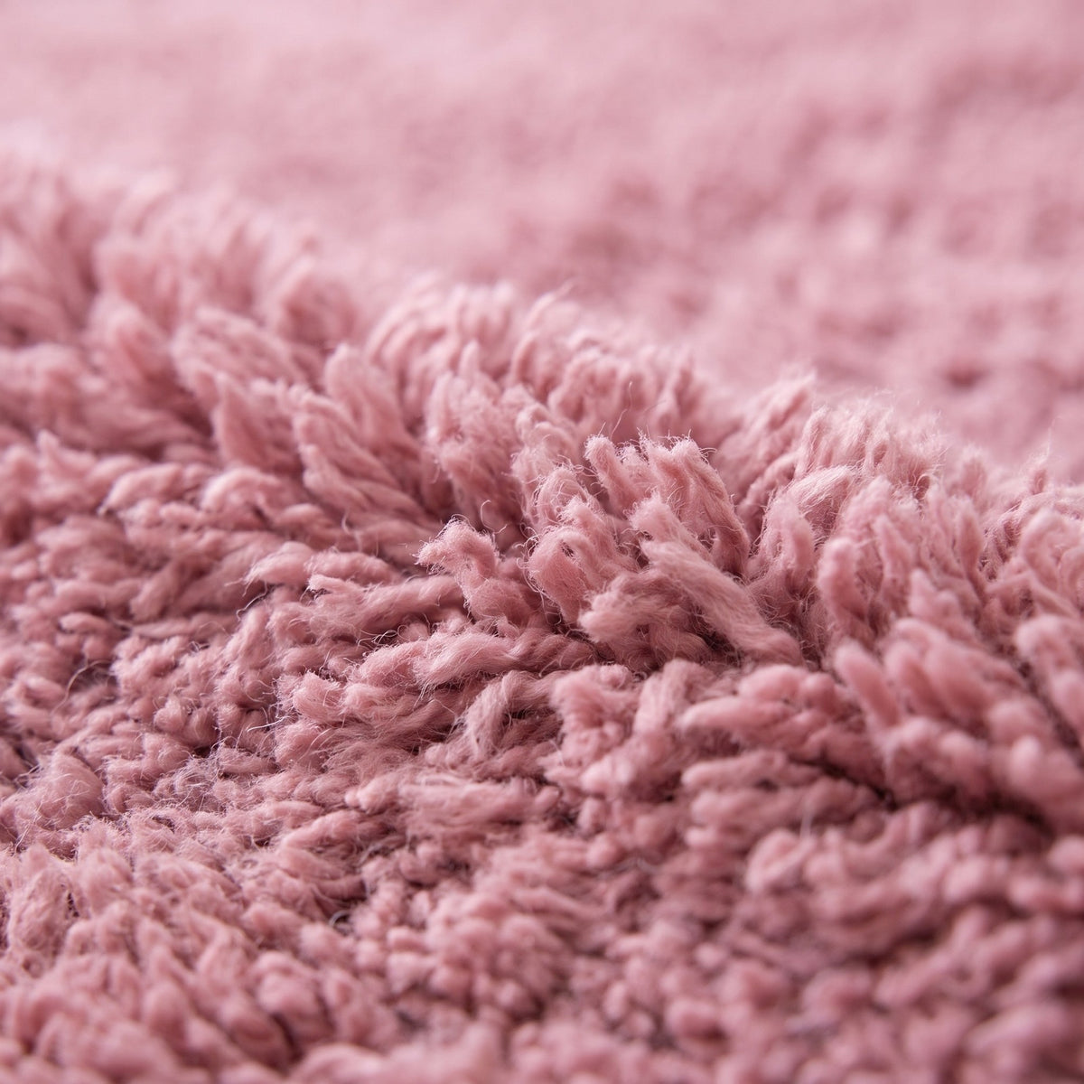Gros plan sur un motif du tapis berbère Tanirt, rose poudré uni sur toute la surface