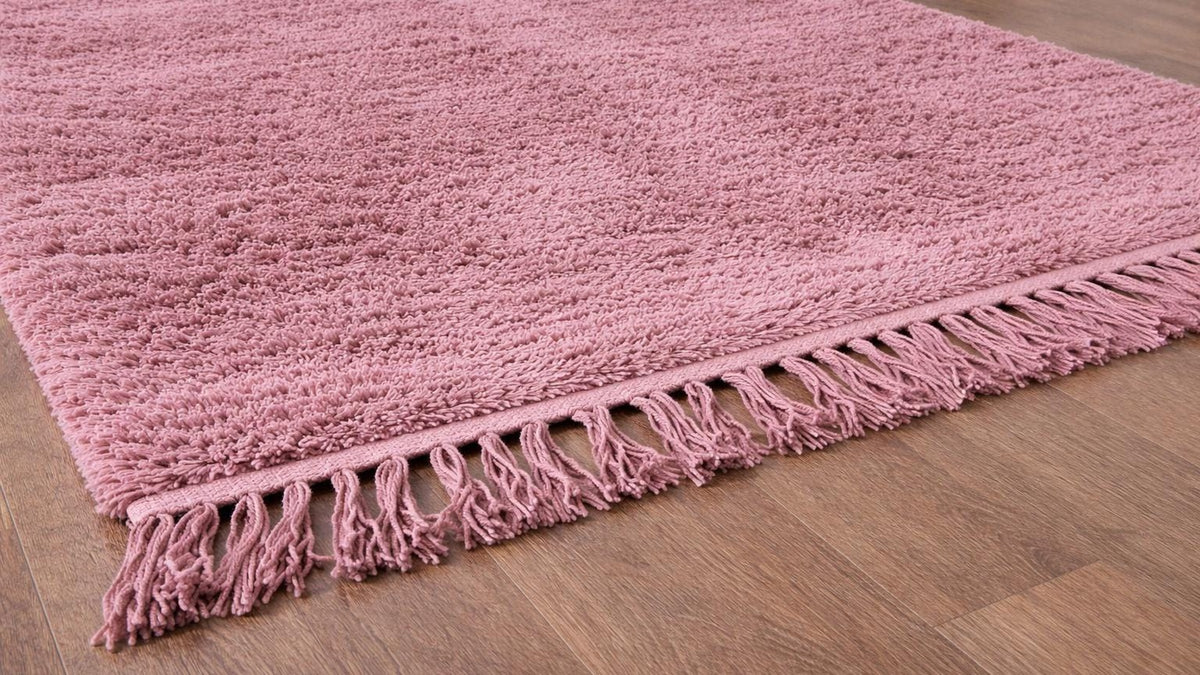 Gros plan sur la laine du tapis berbère Tanirt, poil rose noué à la main