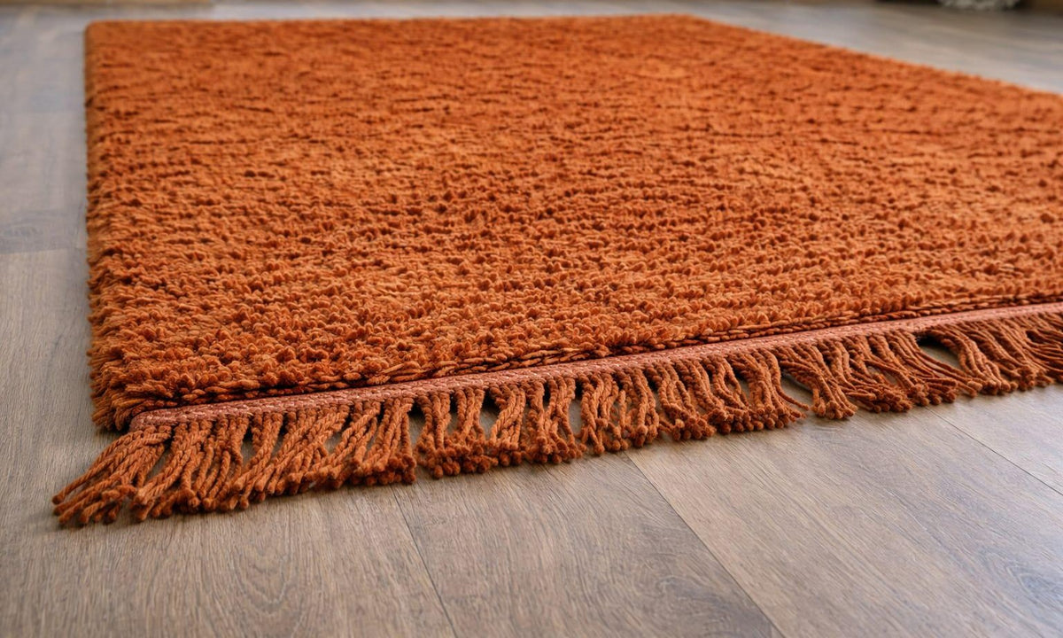 Hagounia plain terracotta Berber rug laid on the floor, seen from the side, hand-knotted in Morocco