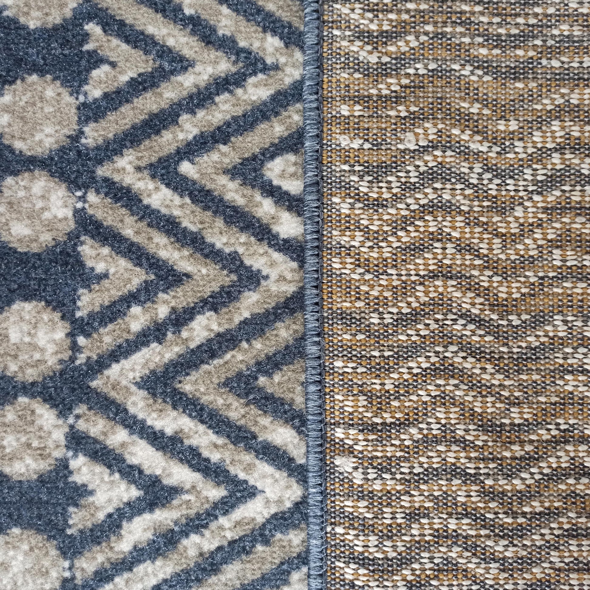 Tapis présentant une surface à motifs géométriques bleus et beiges et son envers tissé aux tons variés
