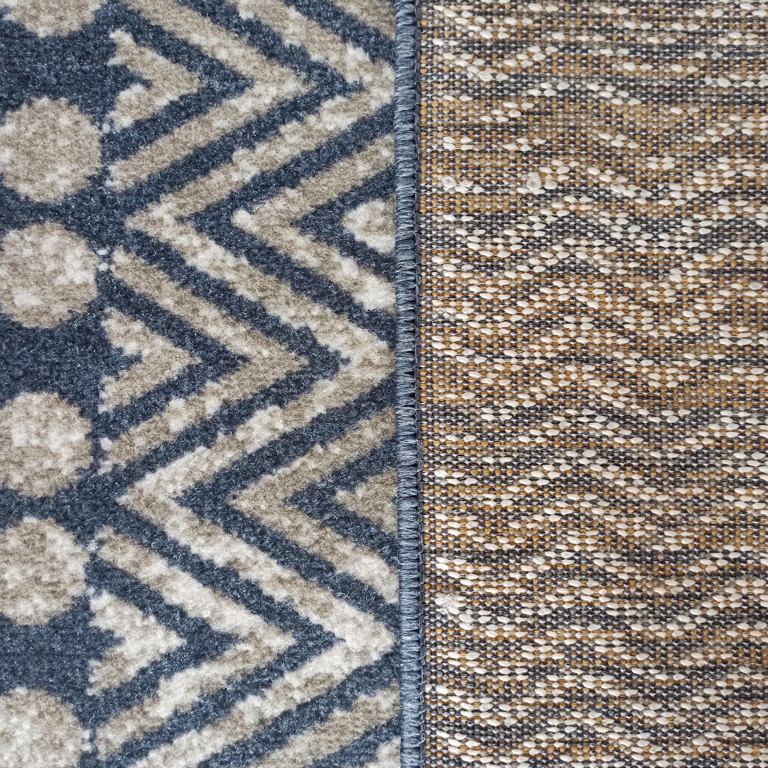 Tapis présentant une surface à motifs géométriques bleus et beiges et son envers tissé aux tons variés