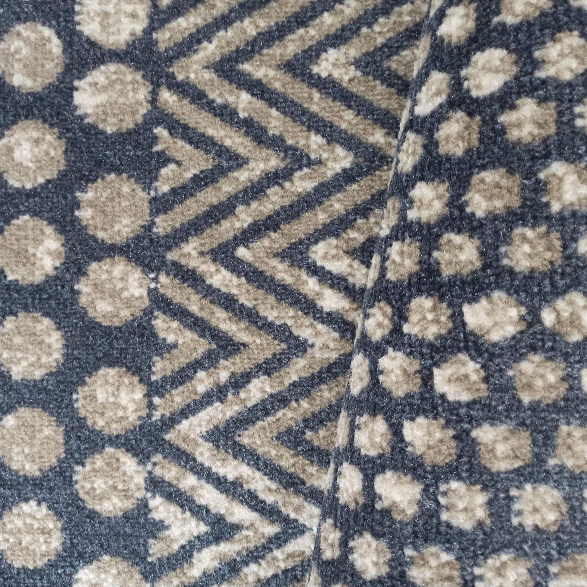 Tapis à poils courts, plié, avec des motifs de taches irrégulières et de chevrons, en bleu foncé et beige