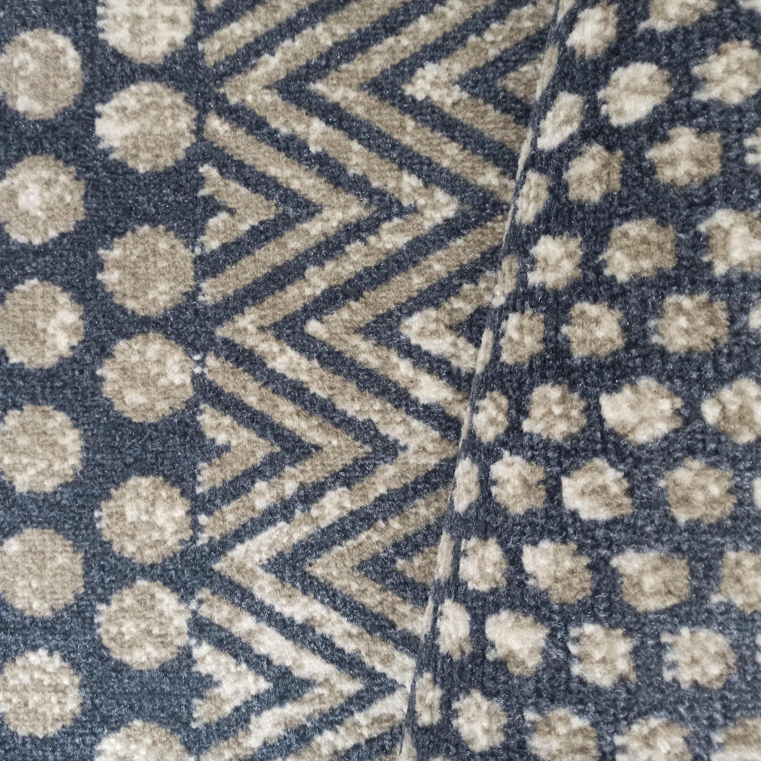 Tapis à poils courts, plié, avec des motifs de taches irrégulières et de chevrons, en bleu foncé et beige