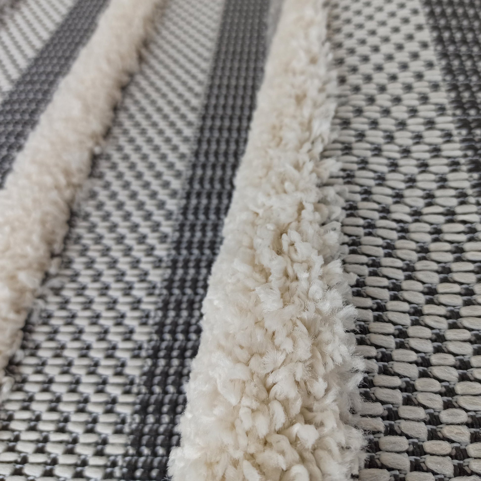 Tapis avec de larges bandes de texture bouclée crème et des motifs tissés gris anthracite et blanc