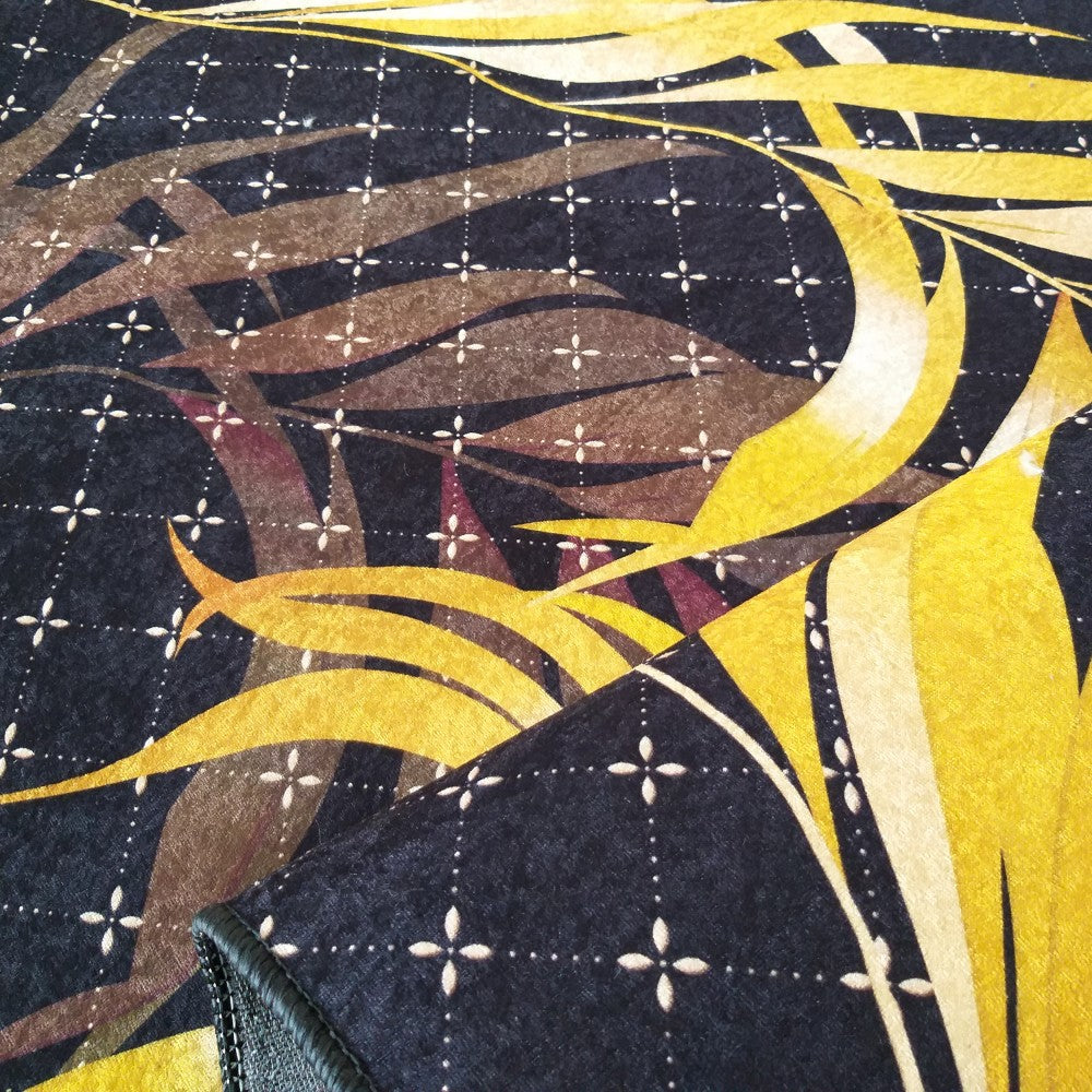 Tapis sombre aux motifs de feuilles jaunes, marron et violacées sur un fond quadrillé de croix claires, avec son bord replié