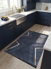 Tapis rectangulaire bleu foncé texturé avec des motifs géométriques abstraits rehaussés de lignes dorées et des franges, dans une cuisine lumineuse