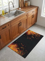 Tapis rectangulaire noir présentant des motifs géométriques de triangles lumineux orange et or avec des éclats, sur un sol de cuisine