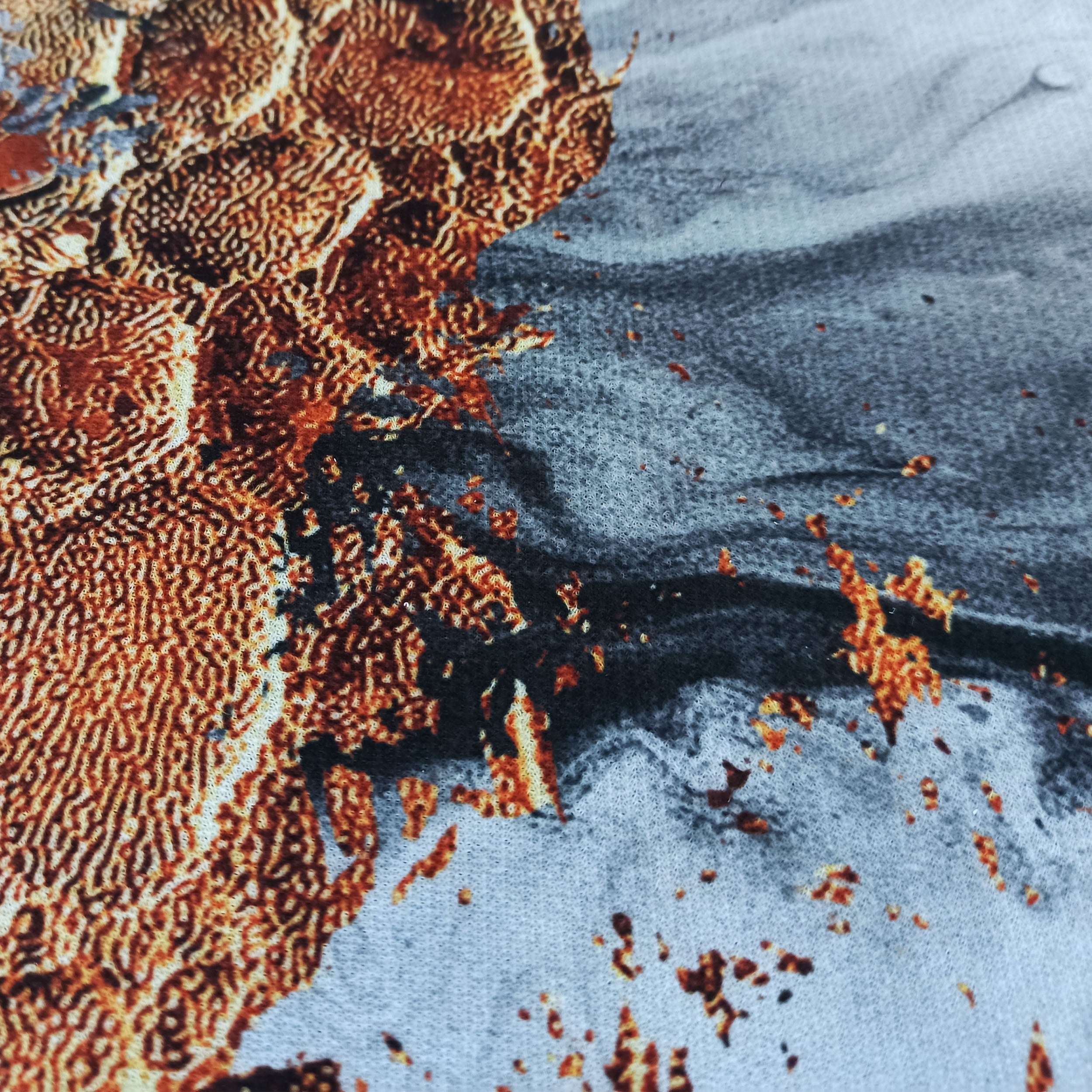 Tapis à motifs organiques complexes brun-orangé, s'estompant vers un fond gris-bleu clair moucheté de noir