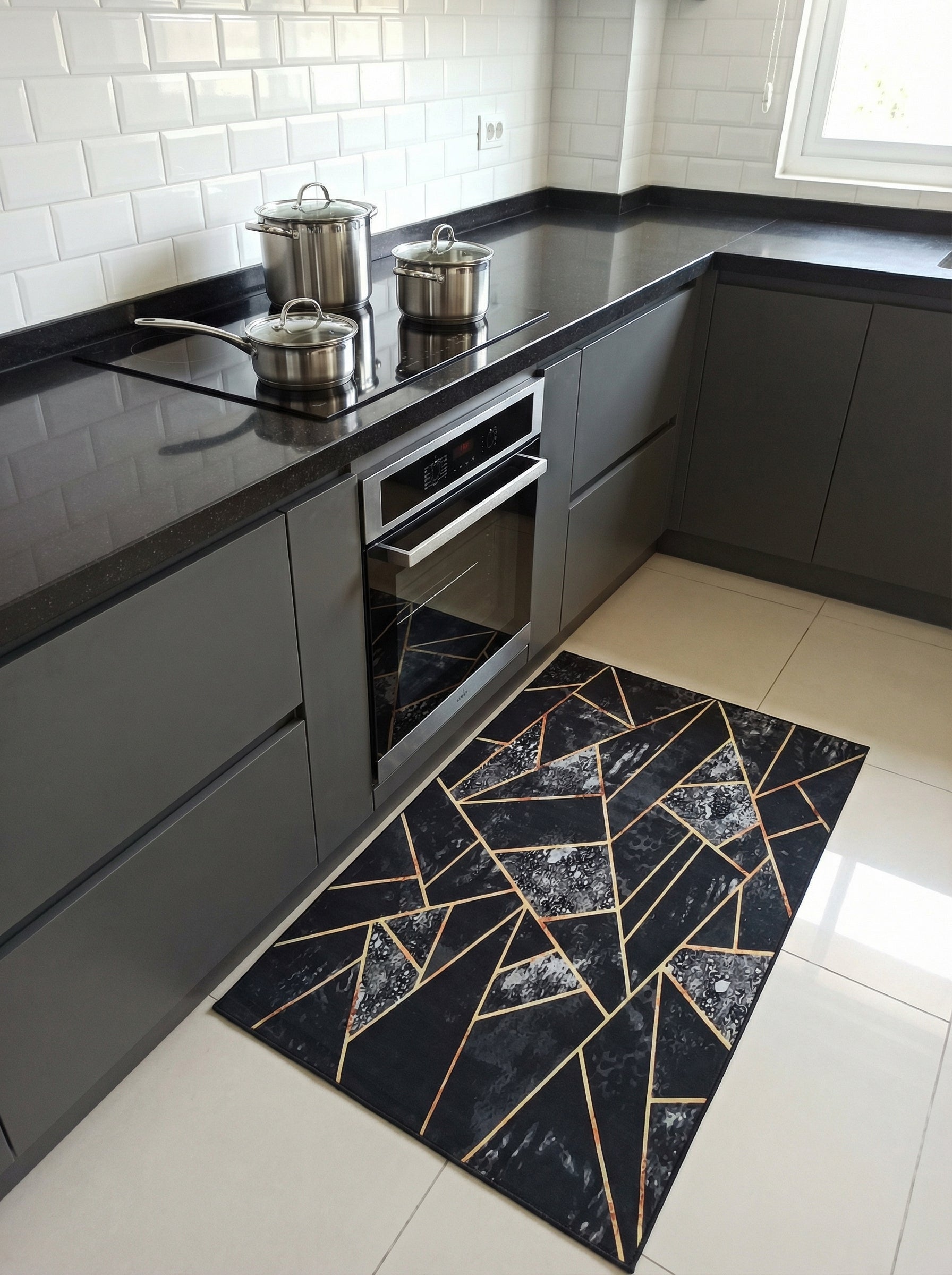 Tapis rectangulaire noir à motifs géométriques dorés et marbrés gris clair, posé sur le sol d'une cuisine moderne