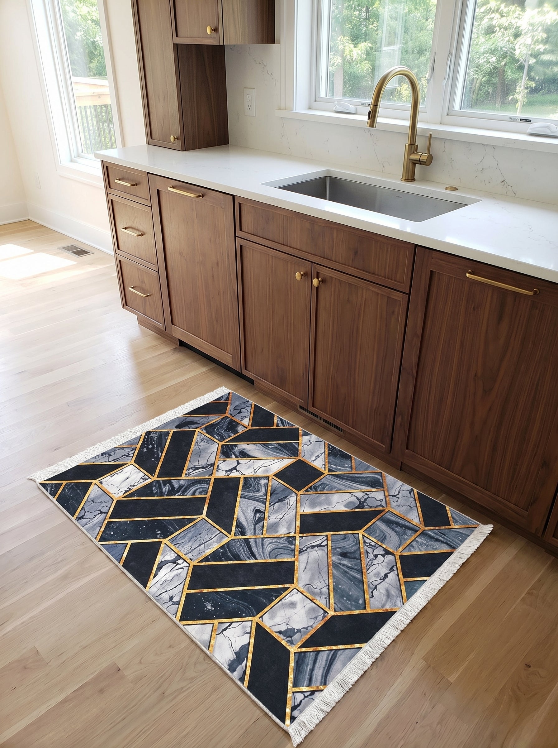 Tapis rectangulaire à motifs géométriques noirs, gris marbré et or, avec franges claires, posé sur un parquet dans une cuisine